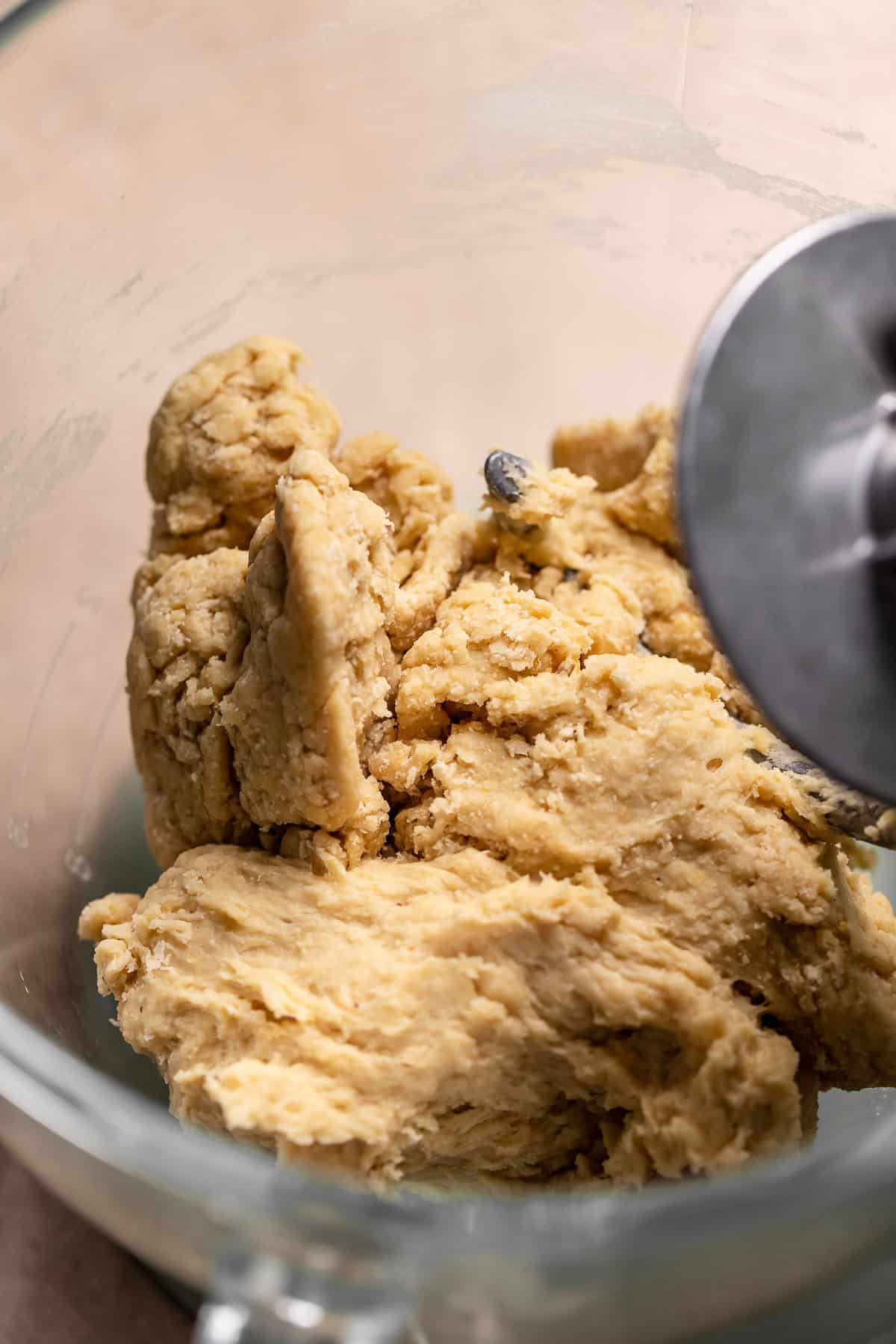 The roughly kneaded dough in a glass mixing bowl.