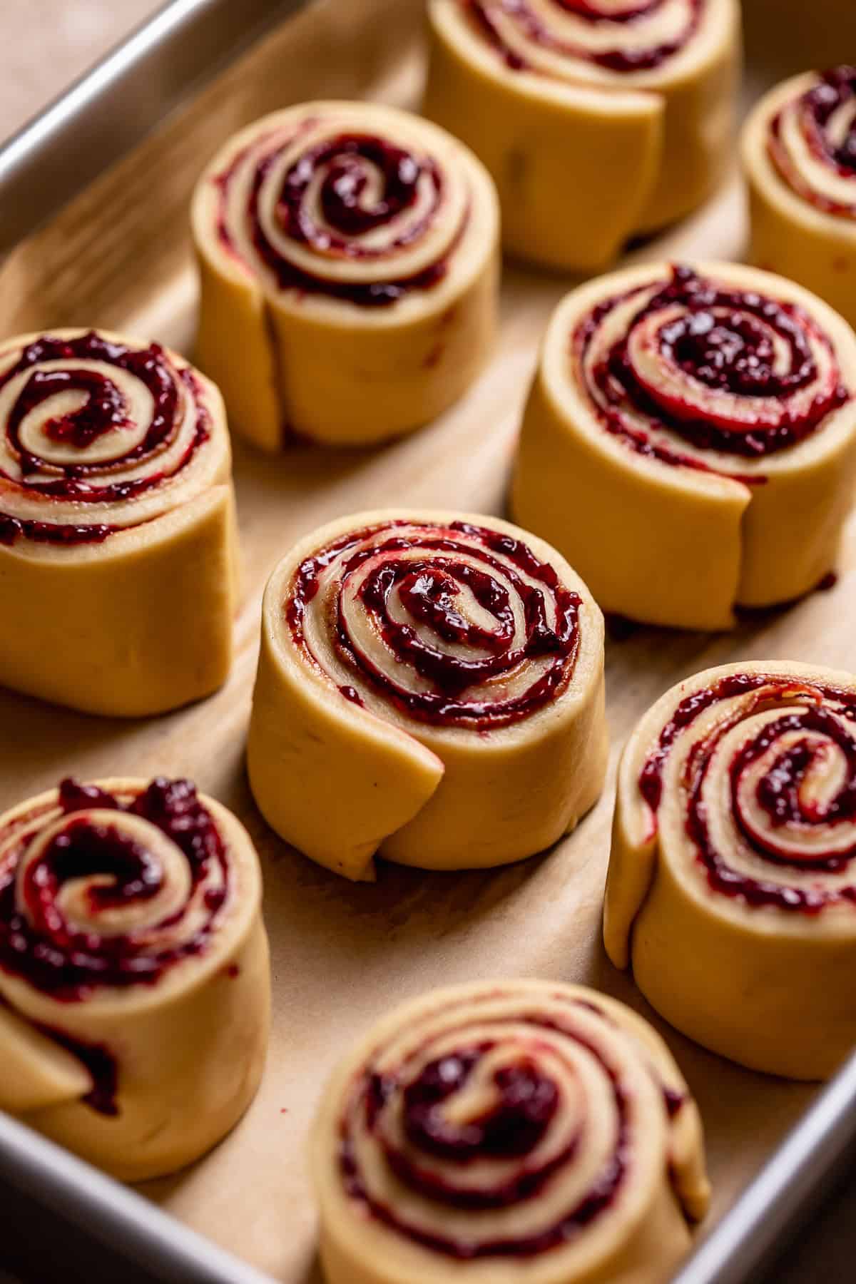 Berry swirled rolls in a baking pan before rising.