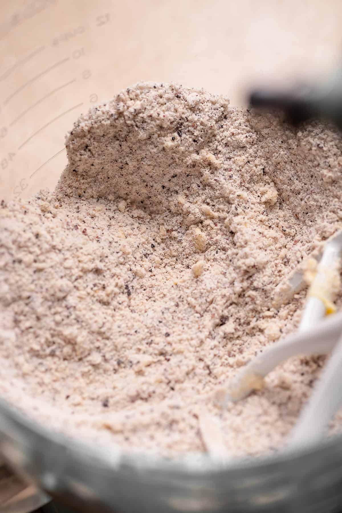 The dry ingredient and butter mixture in a mixing bowl showing the sandy texture.