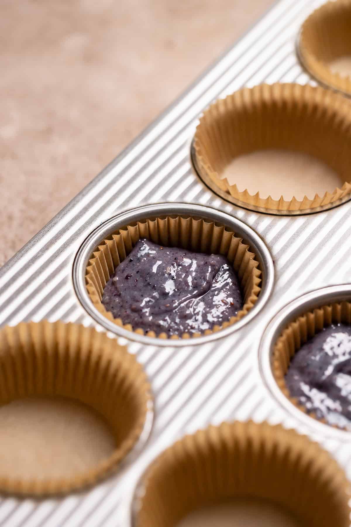 A side view of the cupcake pan to show the batter in the lined cups.