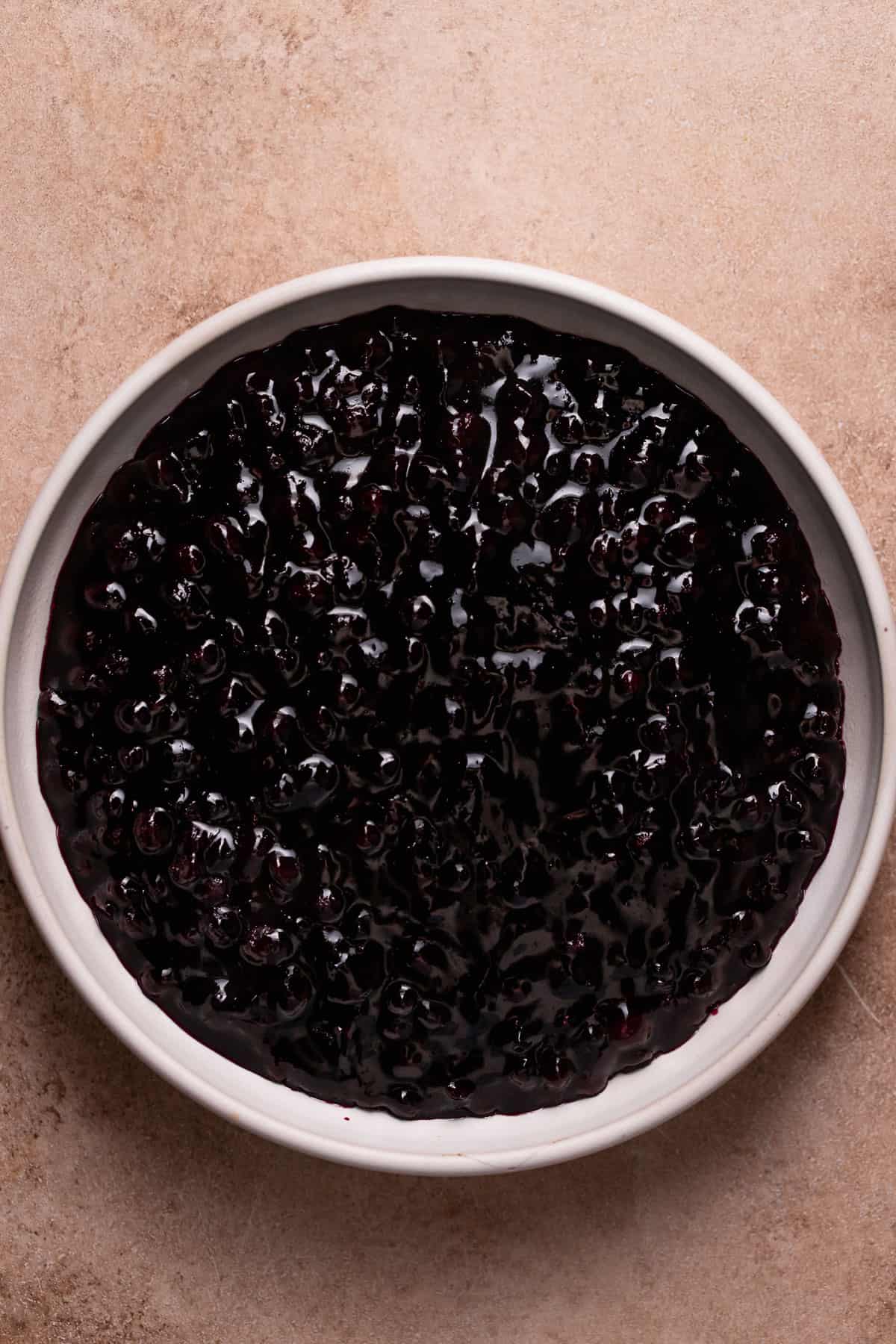 Blueberry jam cooling in a white bowl.