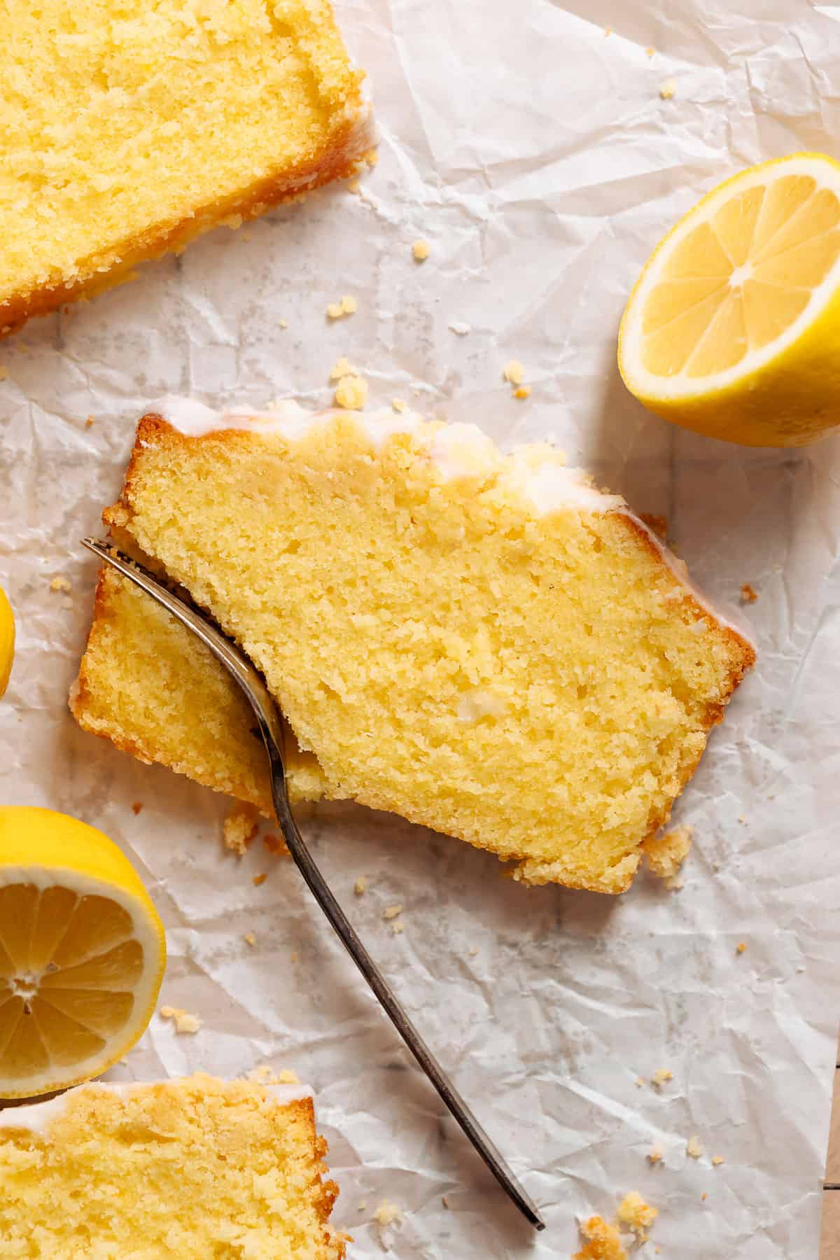 A slice of lemon cake with a fork cutting into it.