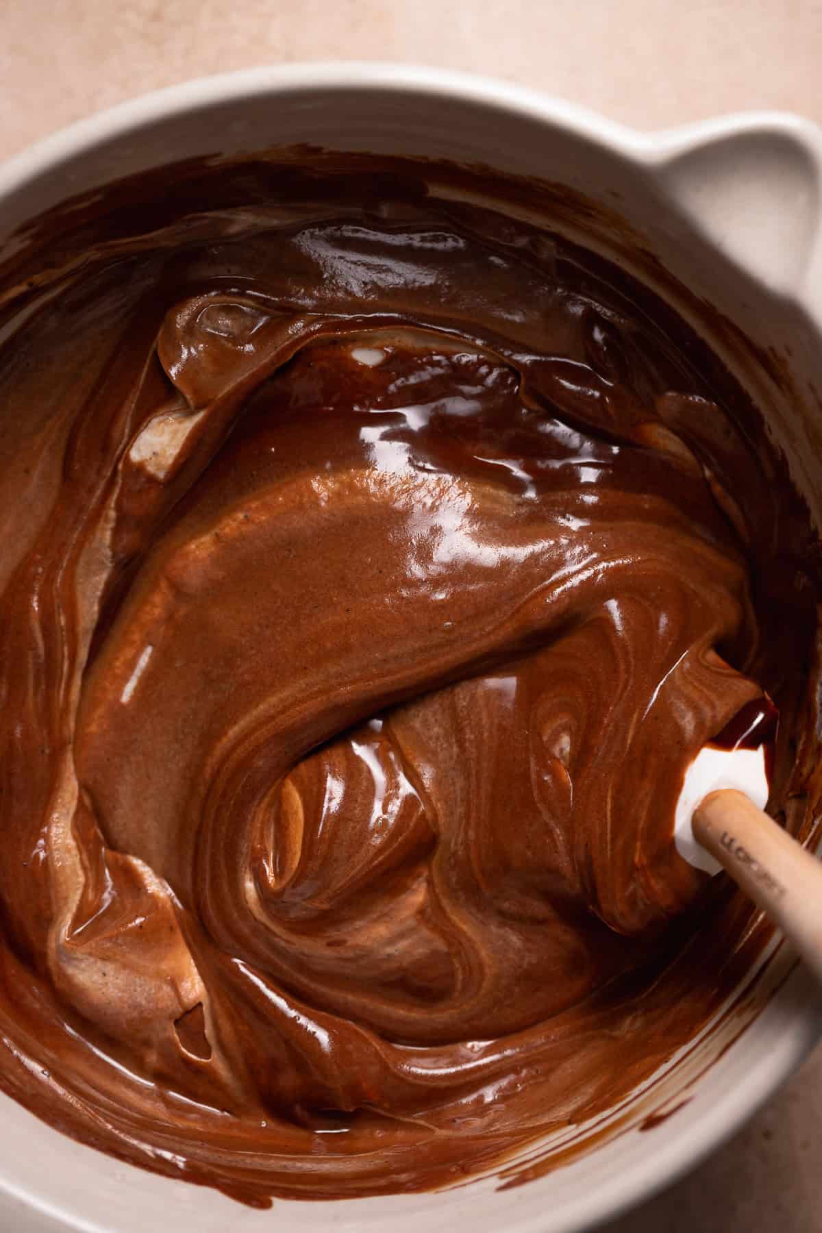 A spatula folding the ganache into the whipped cream.