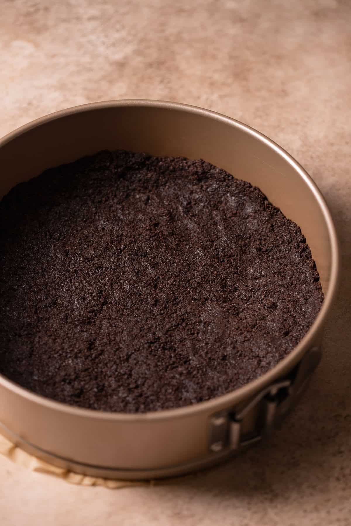 Oreo cookie crust baked into the bottom of a springform cake pan.