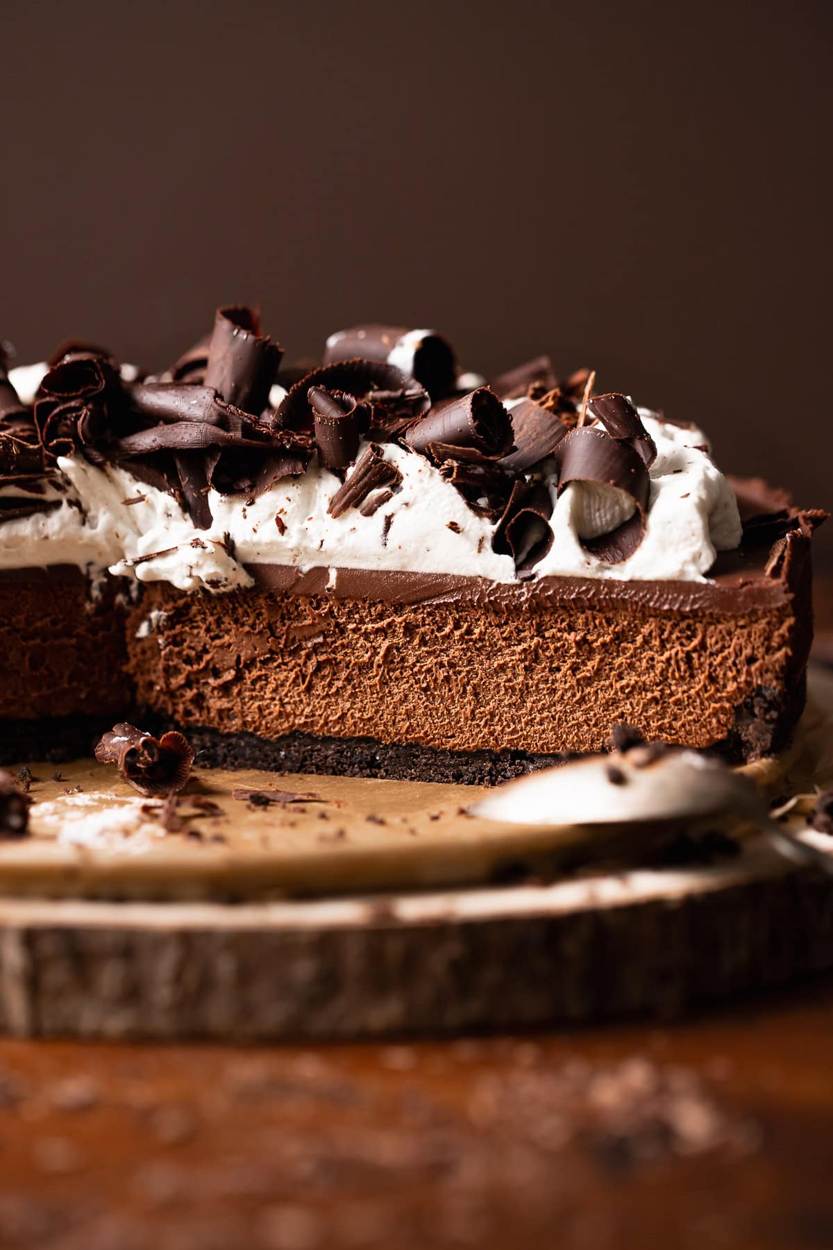 Chocolate mousse pie on a wooden platter with slices missing.