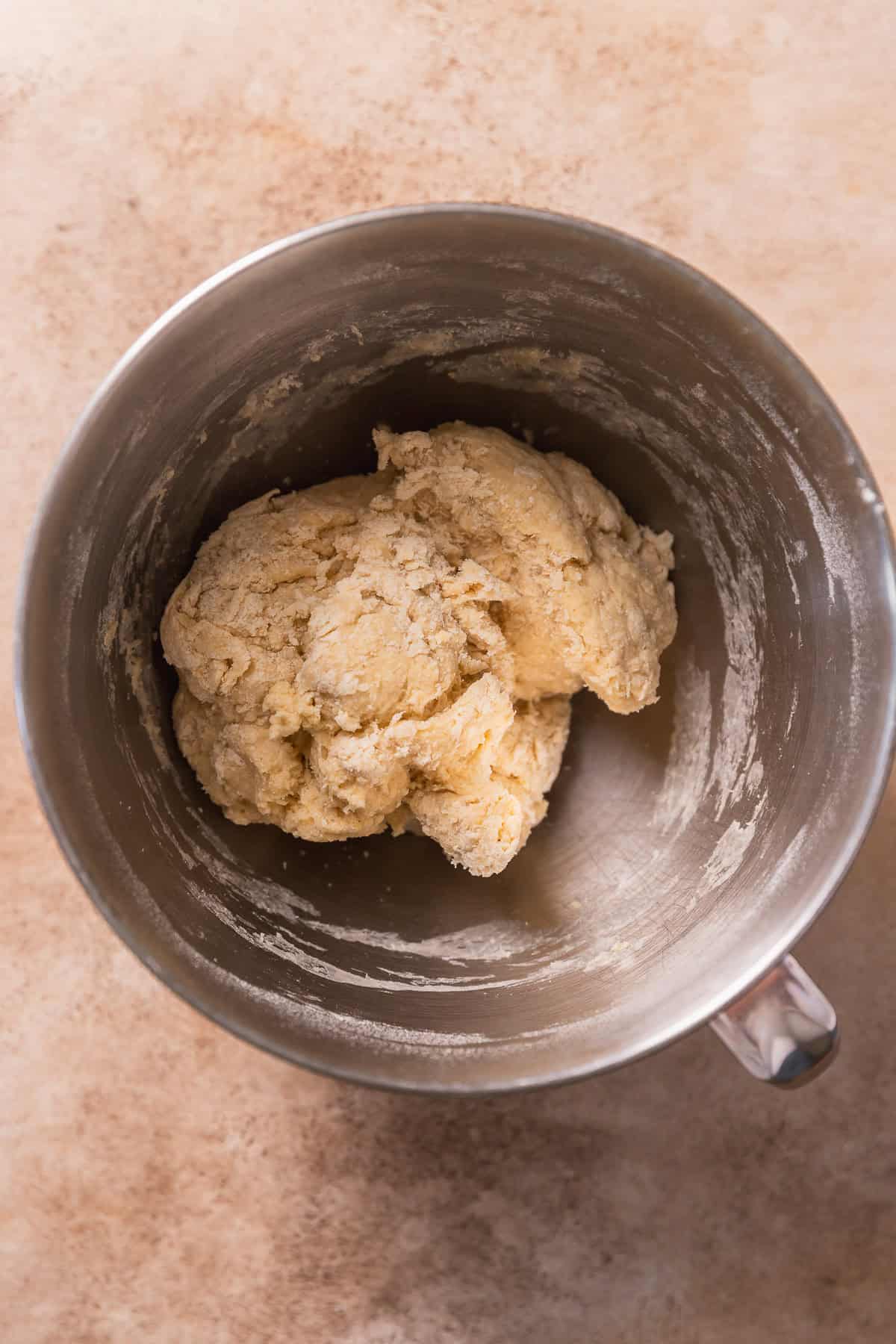 Rough dough in a mixing bowl before kneading in the butter.