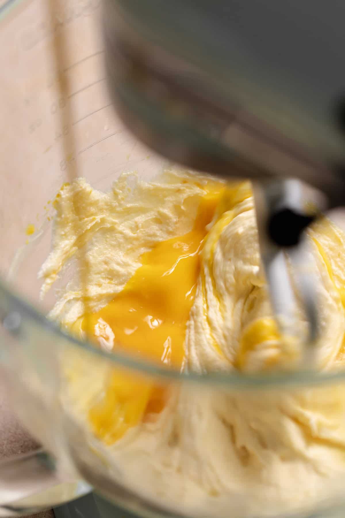 Whisked eggs streaming into a mixing bowl.