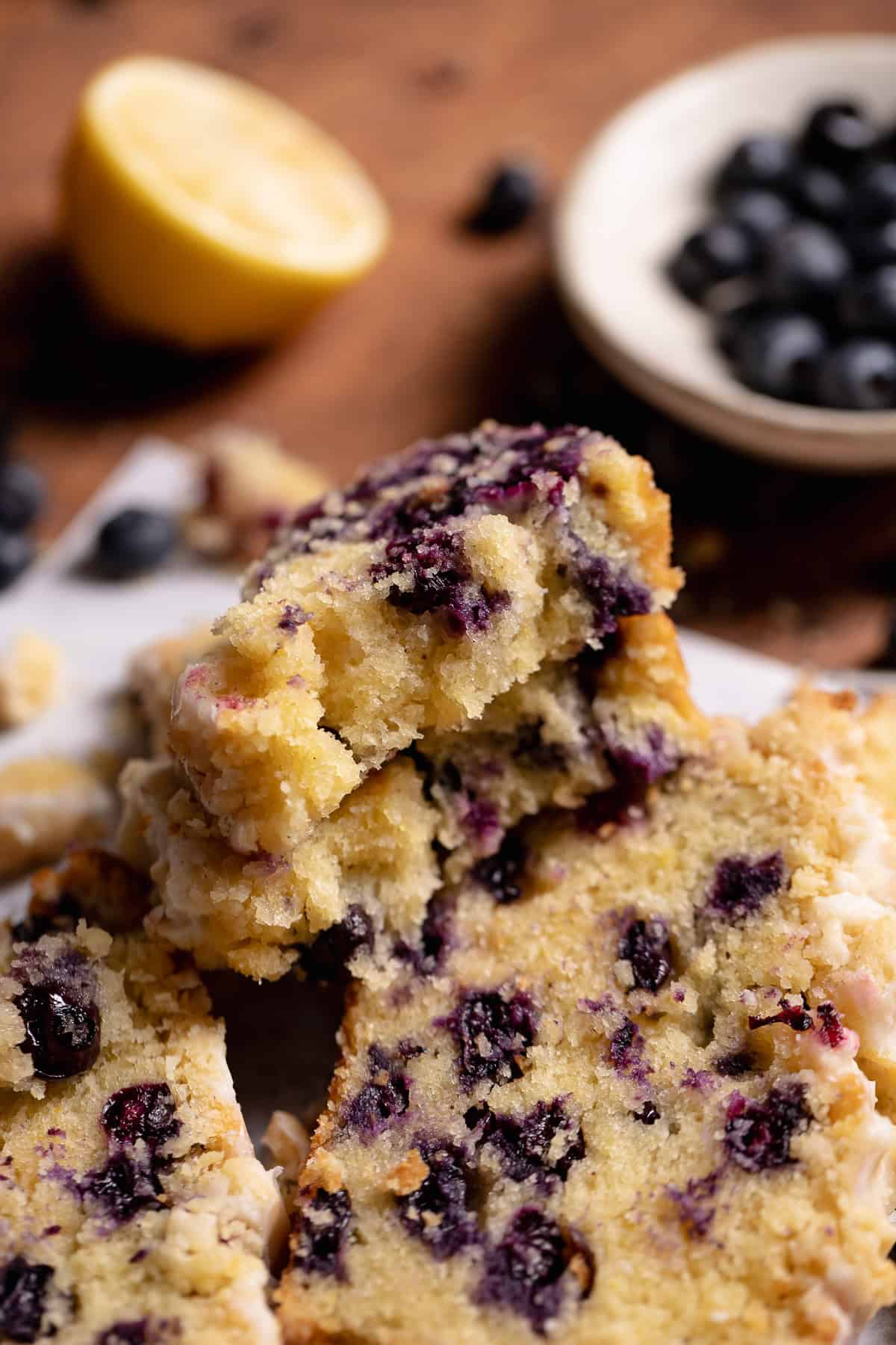 A slice of blueberry bread broken in half to show the moist texture.