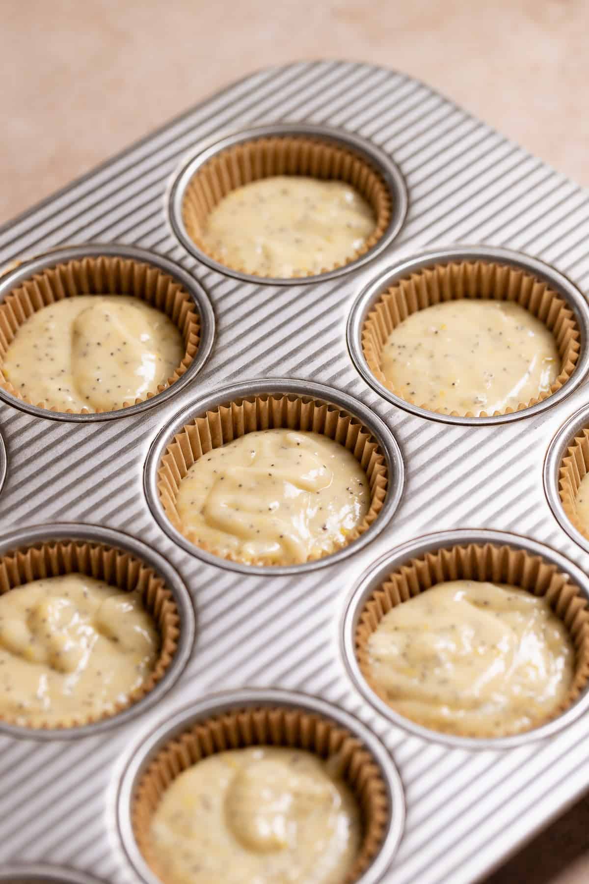 Lemon cupcake batter scooped into cupcake liners before baking.
