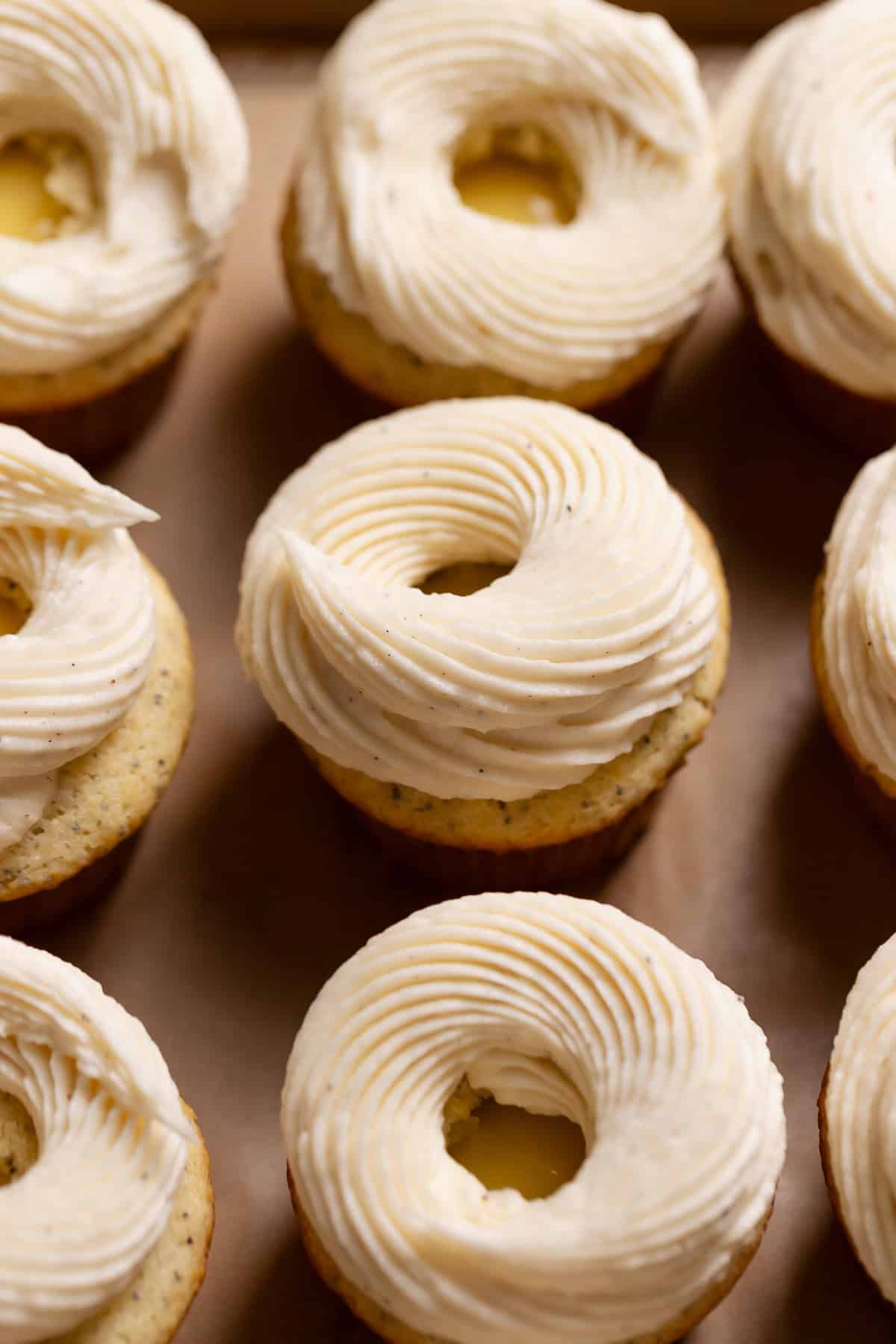 Lemon cupcakes topped with cream cheese frosting.