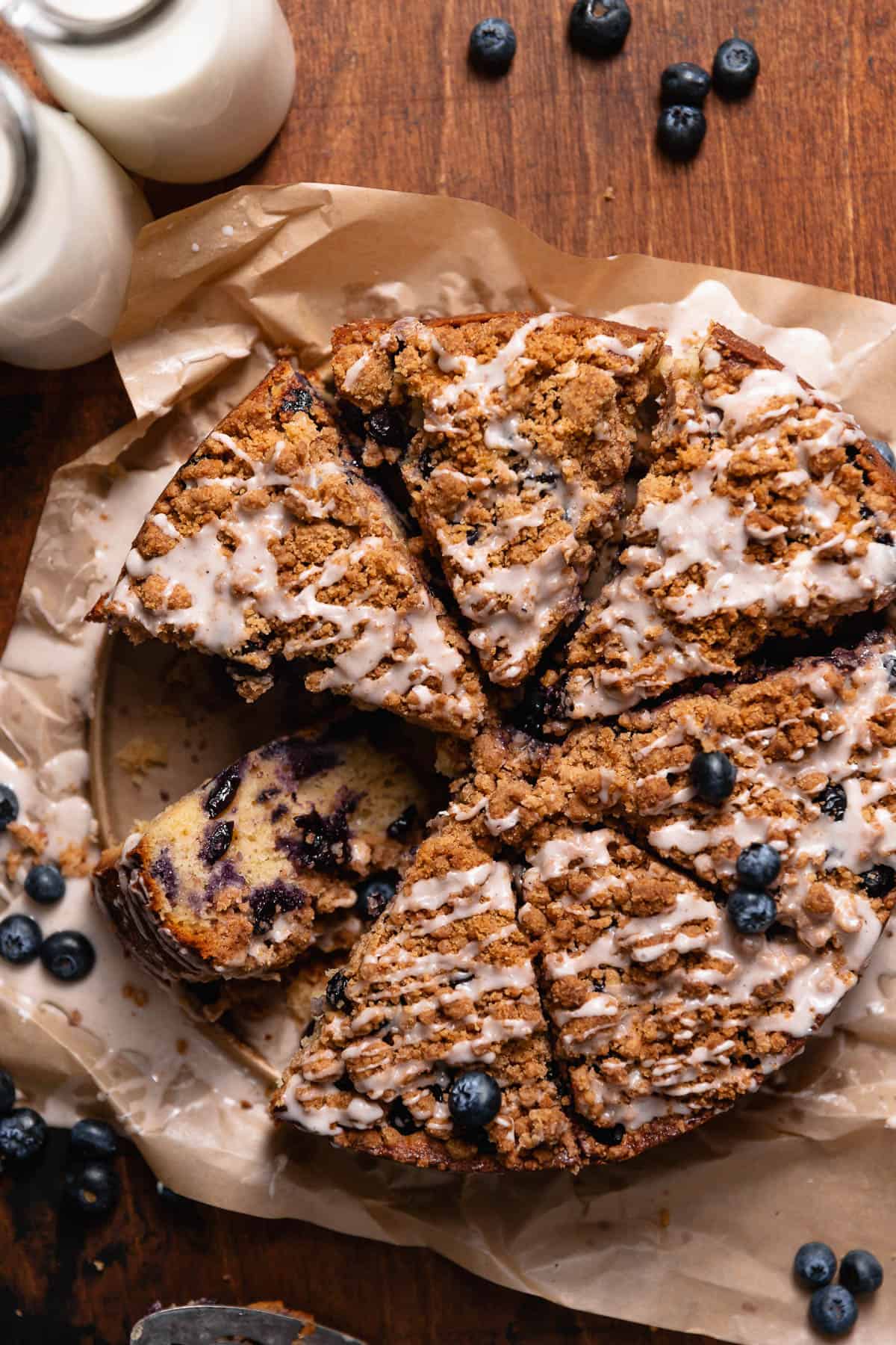 Blueberry coffee cake slices on a wooden backdrop.
