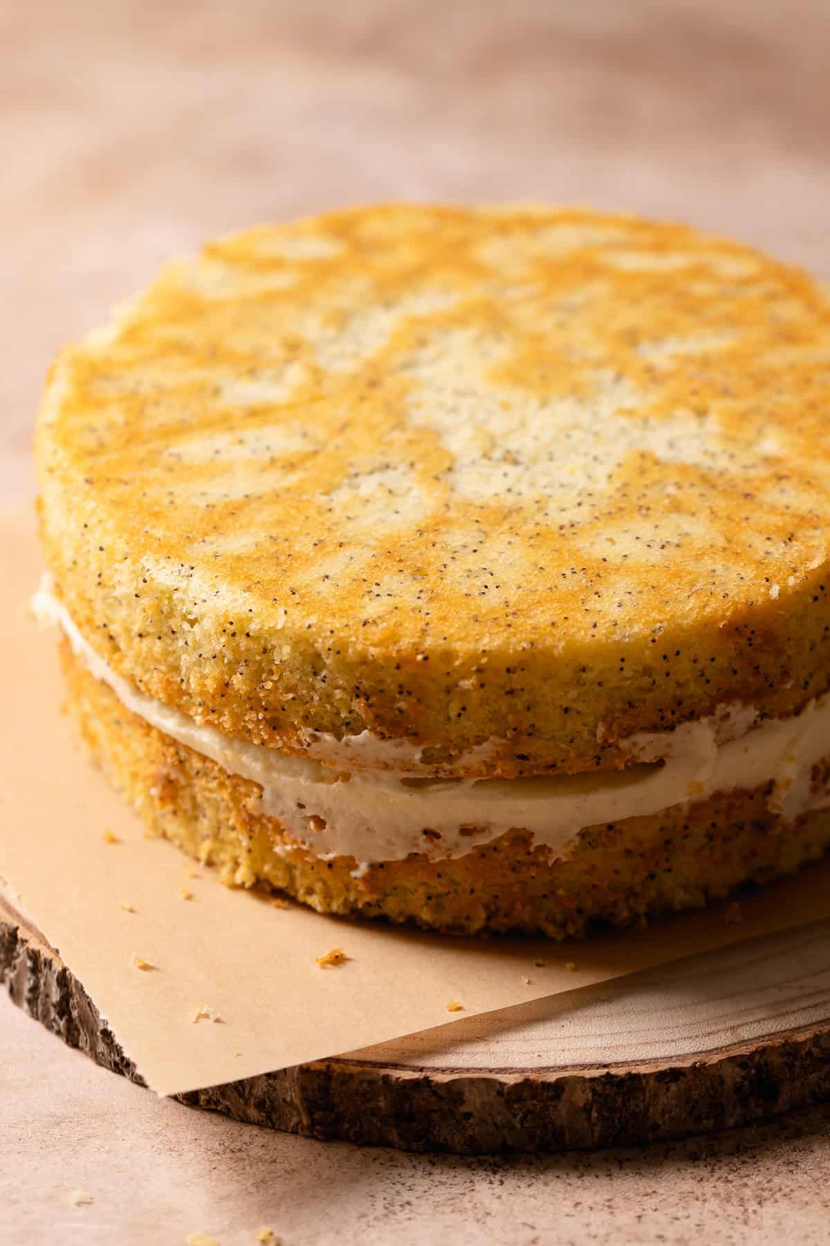 Lemon poppy cake with lemon curd center on a wooden platter with no frosting.