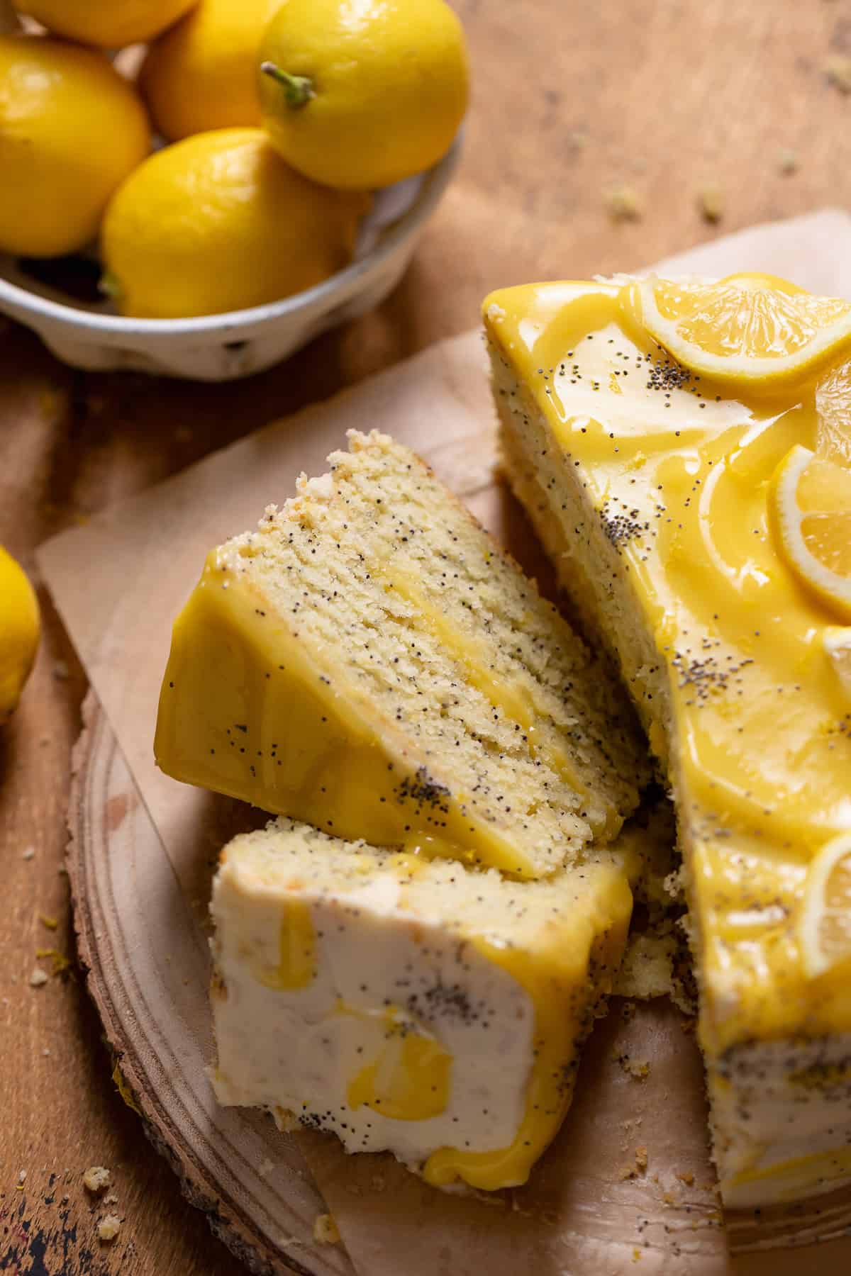 Slices of lemon poppy seed cake on a wooden backdrop.