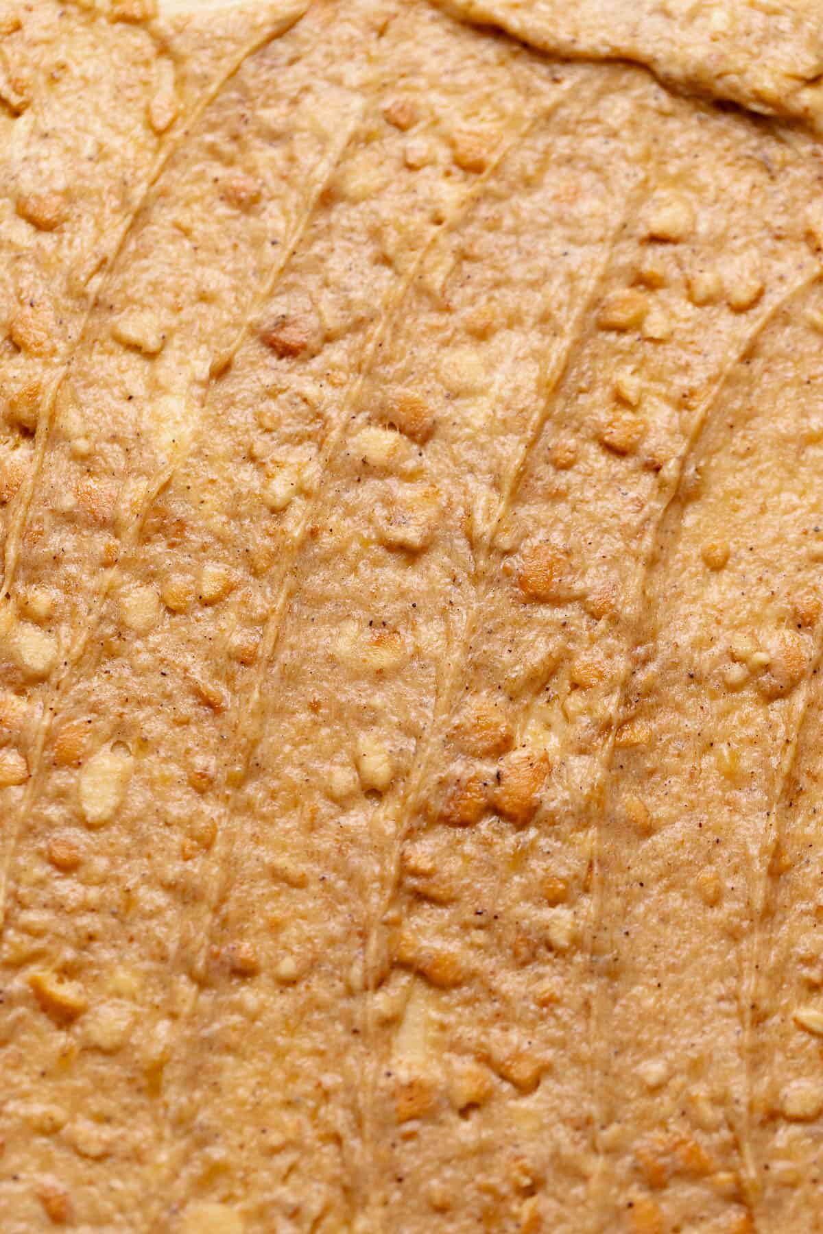 Cinnamon dough rolled out with the banana pudding filling spread across it.