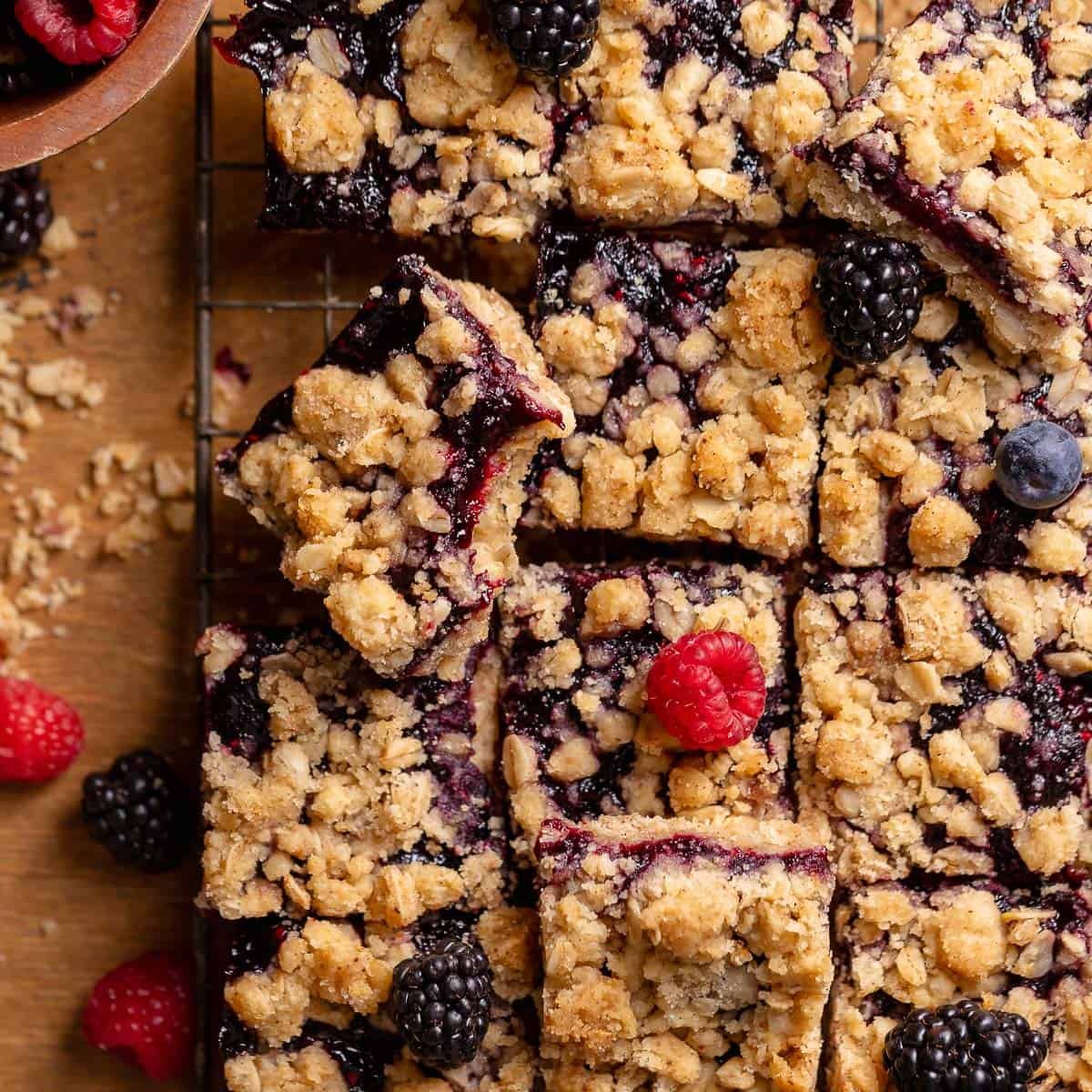 Brown sugar berry crumble bars topped with fresh raspberries, blackberries, and blueberries.