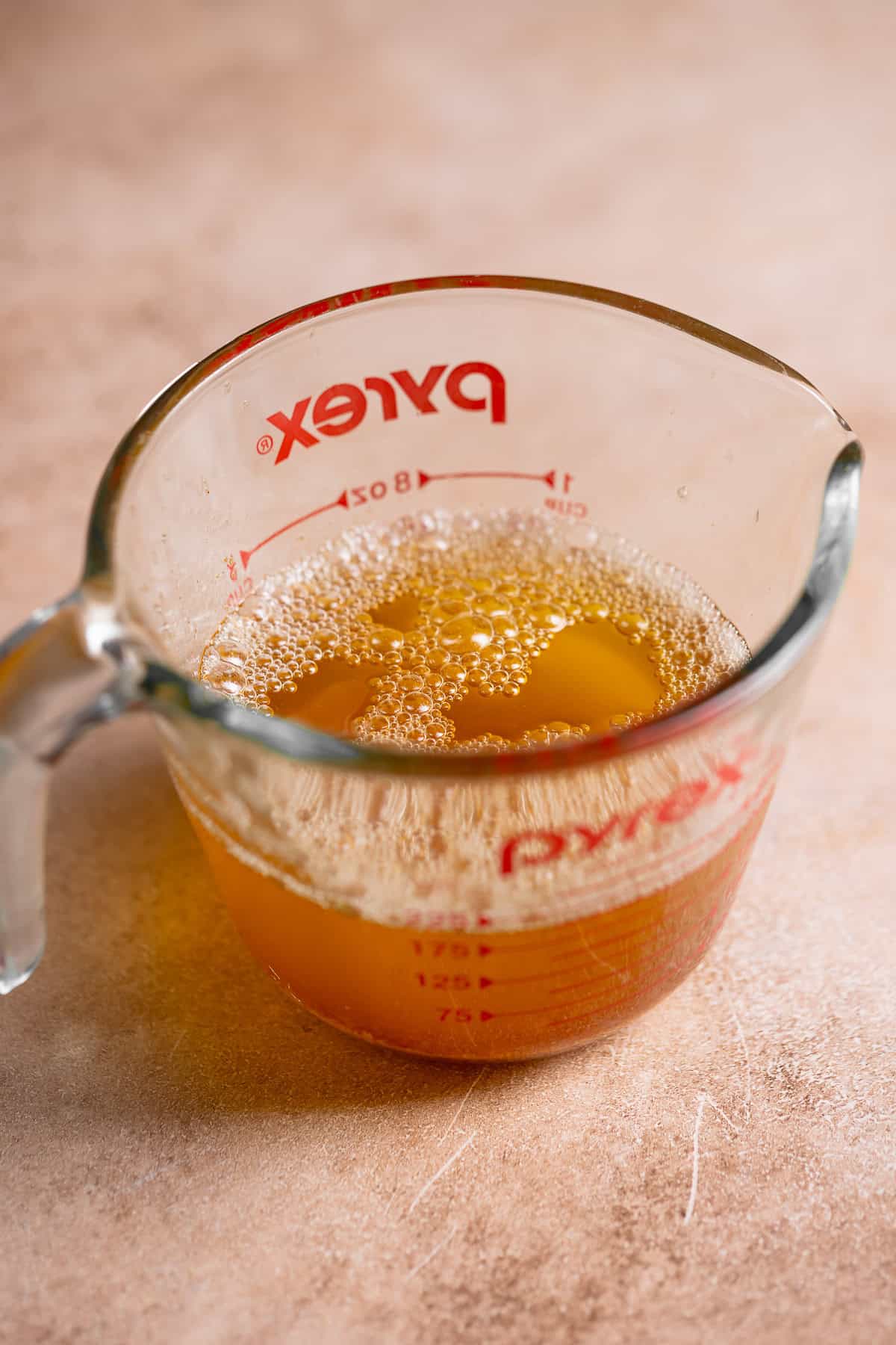A glass measuring cup full of liquid brown butter.