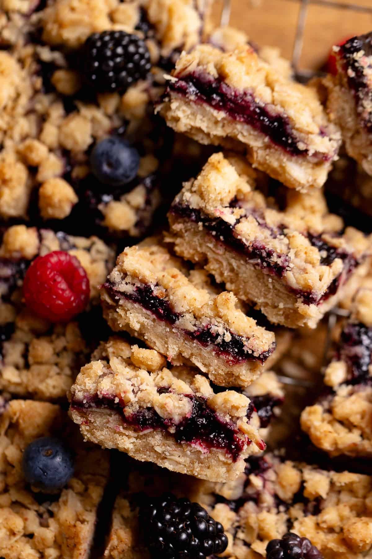 Four fruit crumble bars on their sides to show the jammy fruit filled centers.
