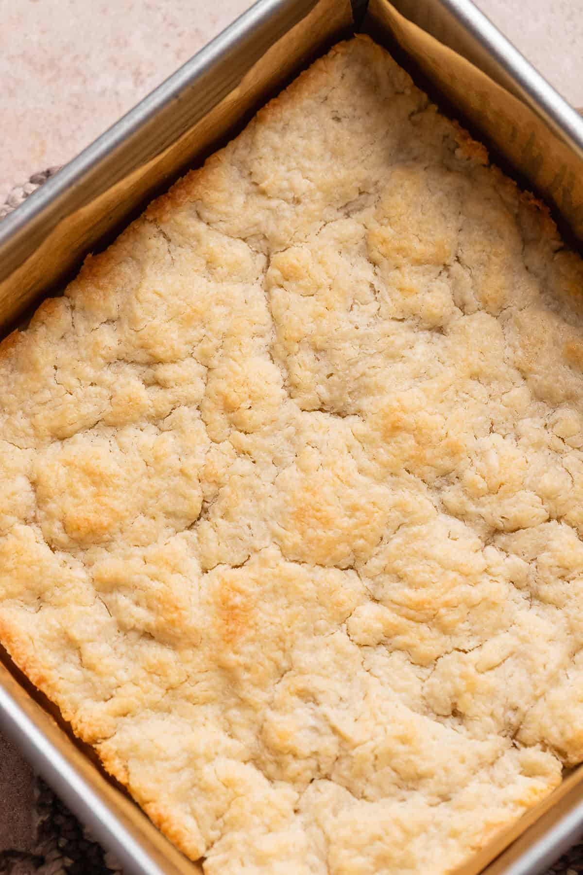 The baked pie dough crust with golden brown edges in a baking pan.