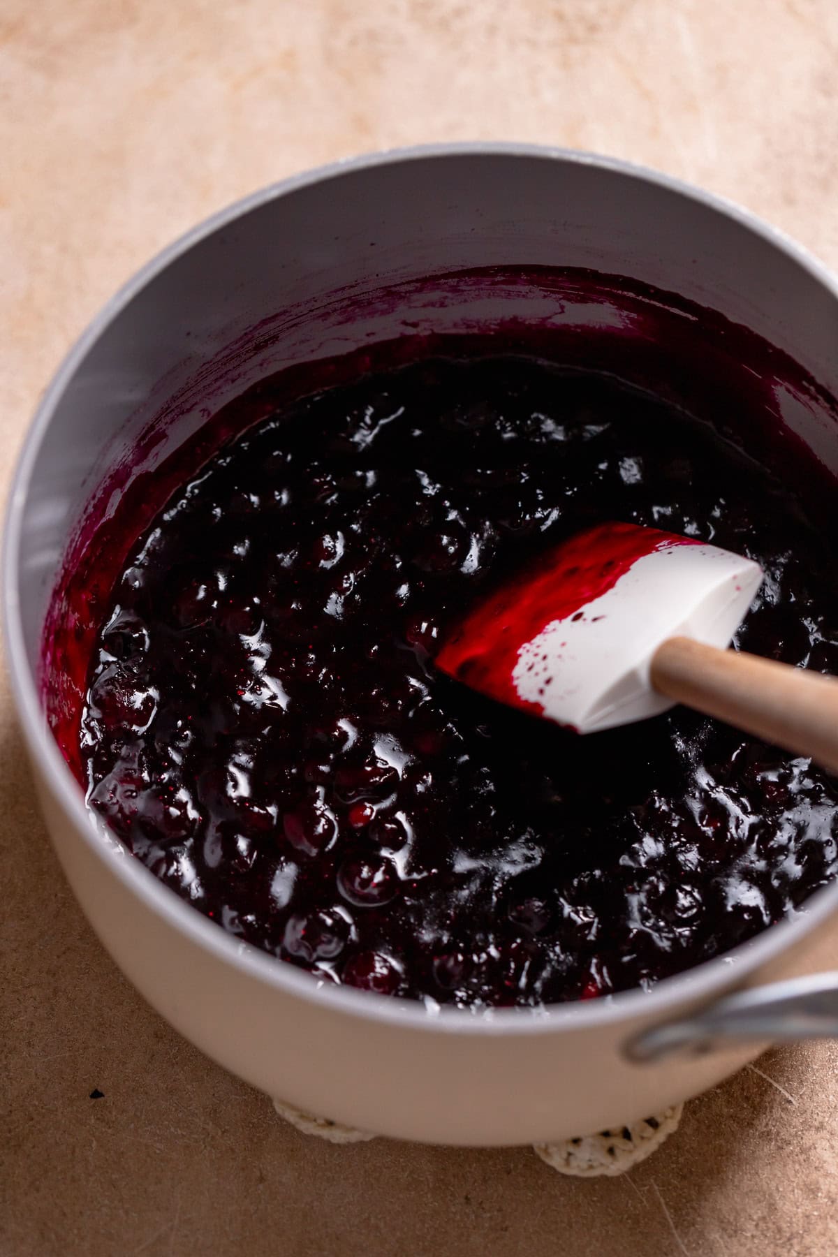 Blueberry pie filling in a white pot.