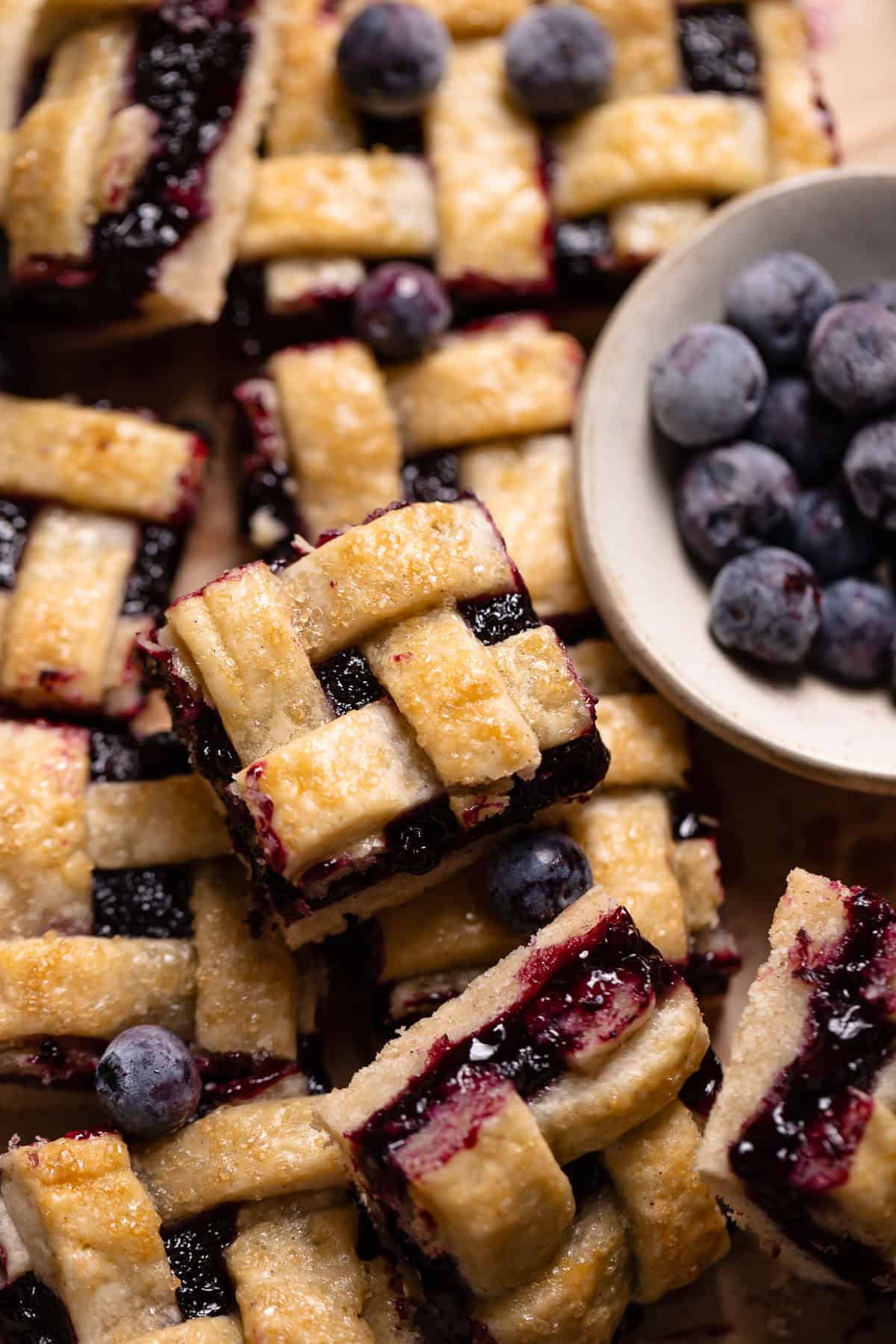 Blueberry pie bars with lattice tops in a pile.