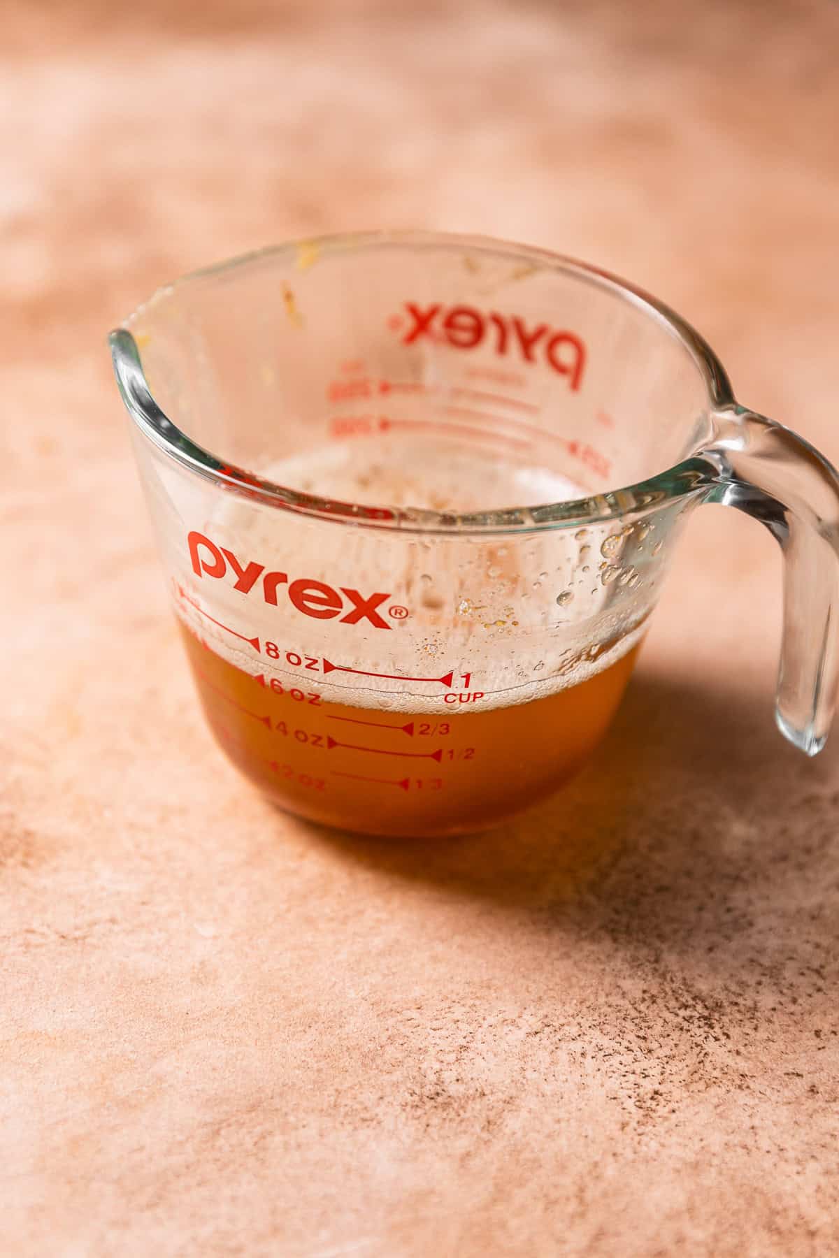 A glass measuring cup with liquid brown butter.