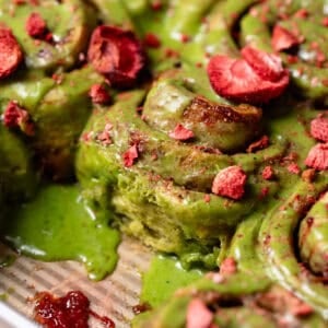 Strawberry matcha cinnamon rolls in a baking pan.
