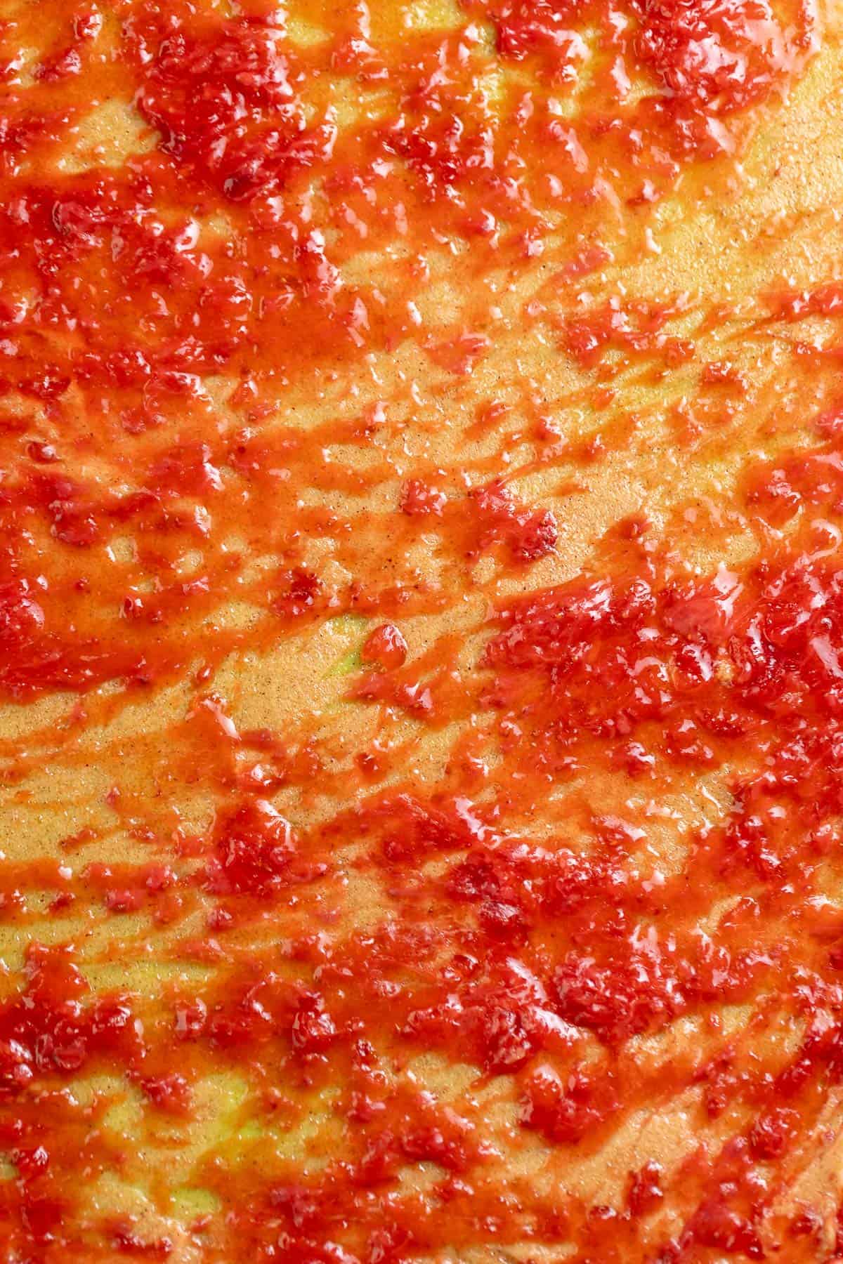 Strawberry jam and cinnamon sugar spread onto the matcha dough.