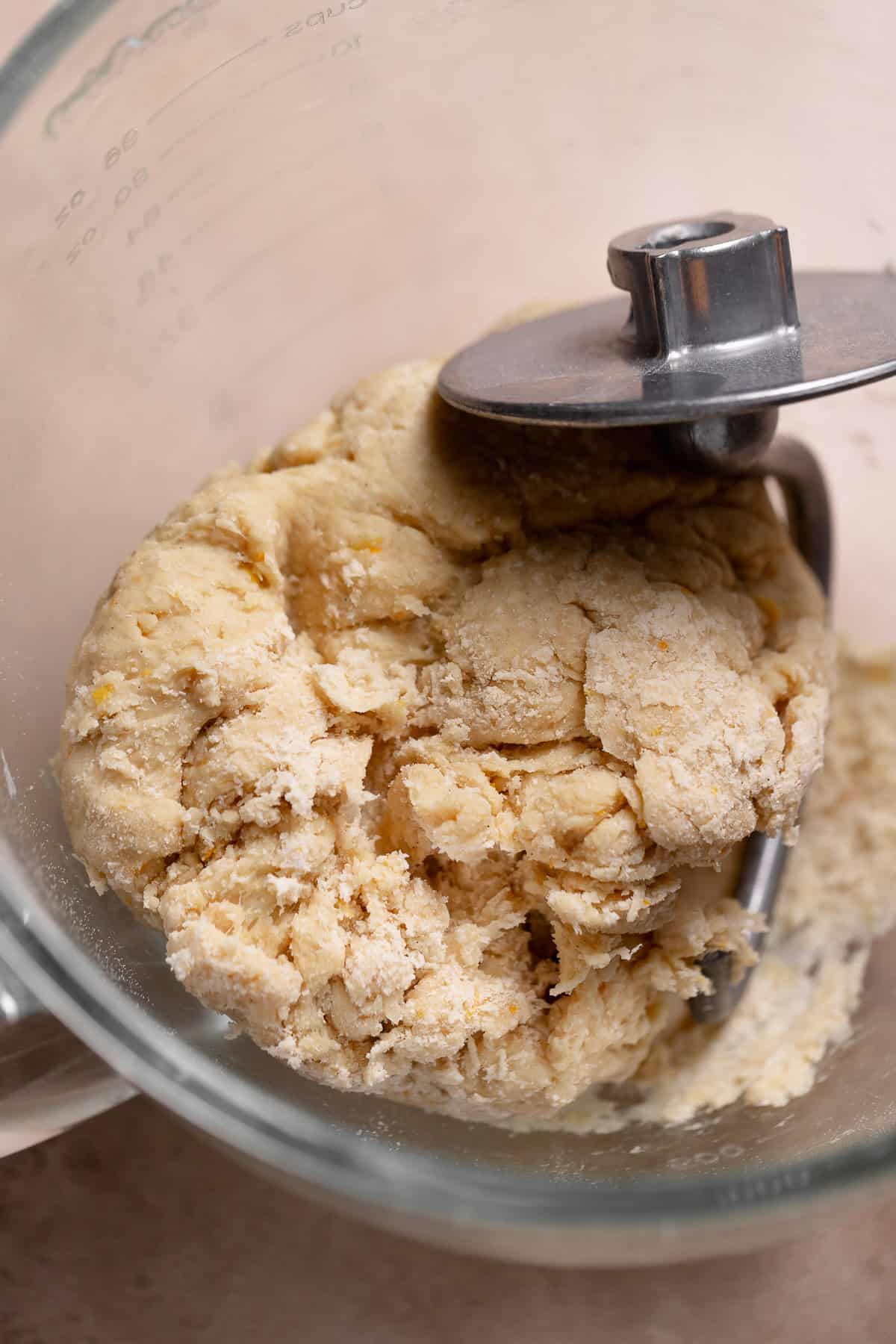 A rough, dry dough ball in a mixer bowl.