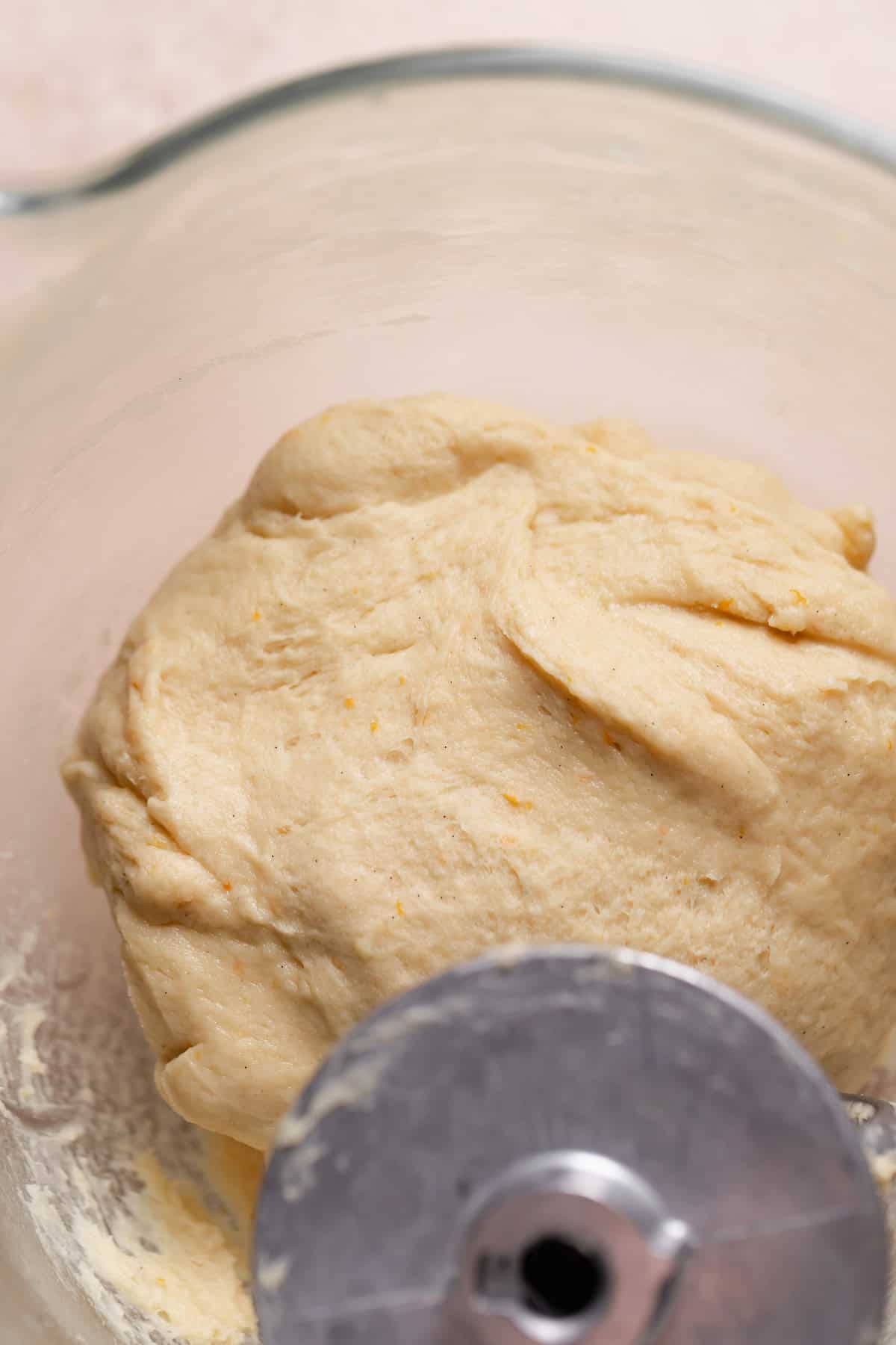 Soft, kneaded orange zest dough in a mixer bowl.