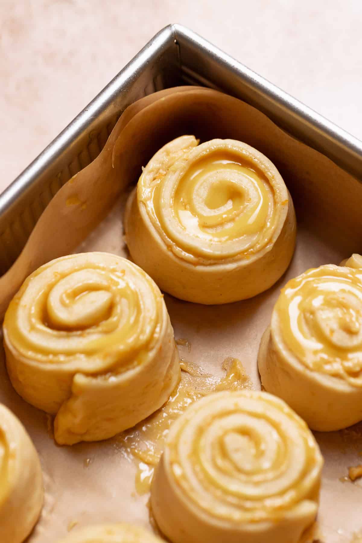 Orange buns in a baking pan before they double in size.