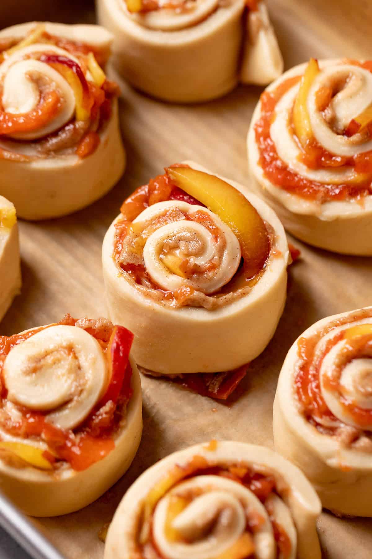 Peach rolls in a baking pan before baking.