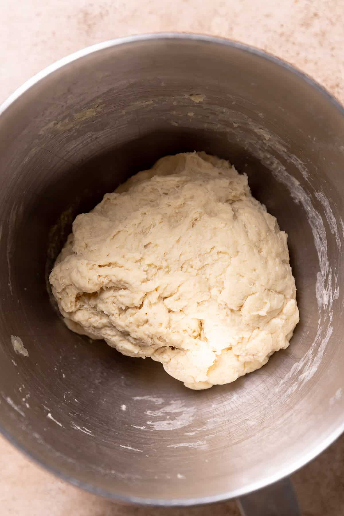 A mixing bowl with a rough dough ball.