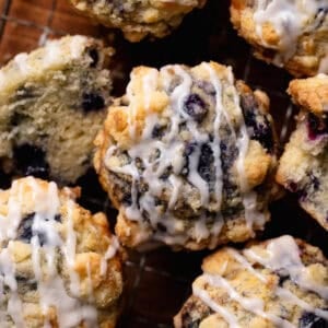 An overhead shot of the crumb topped blueberry muffins drizzled with vanilla glaze.