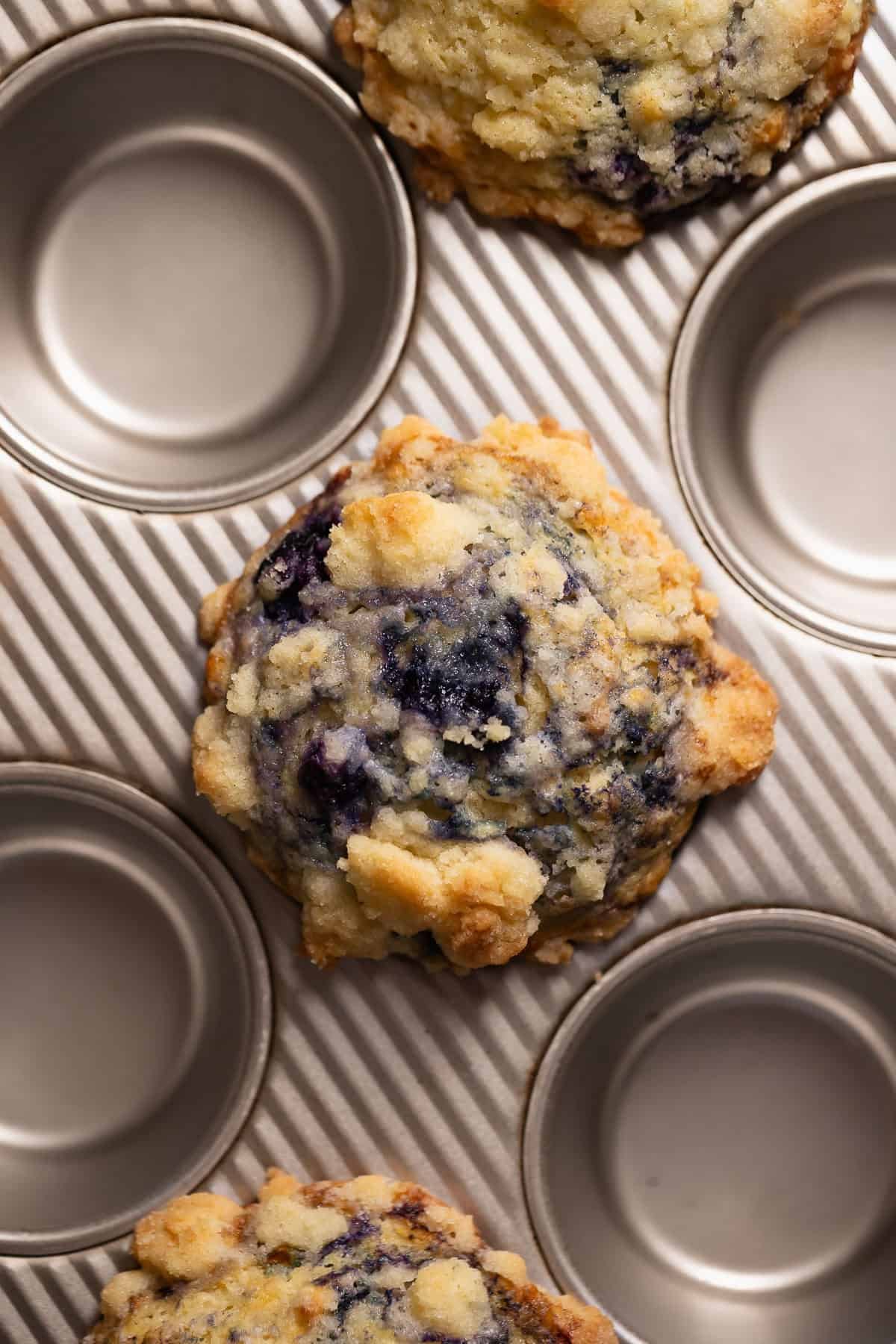 Baked blueberry muffins in a muffin pan.
