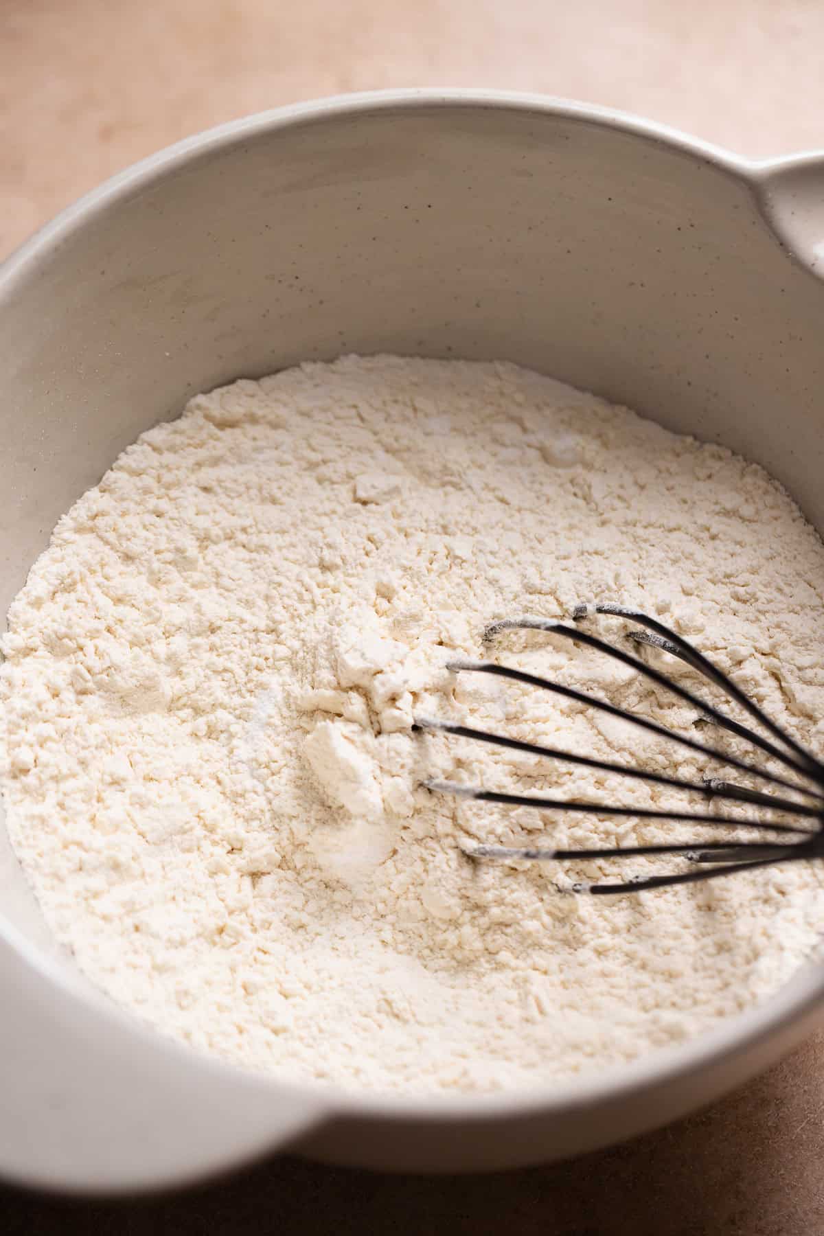 Dry ingredients in a bowl being whisked together.