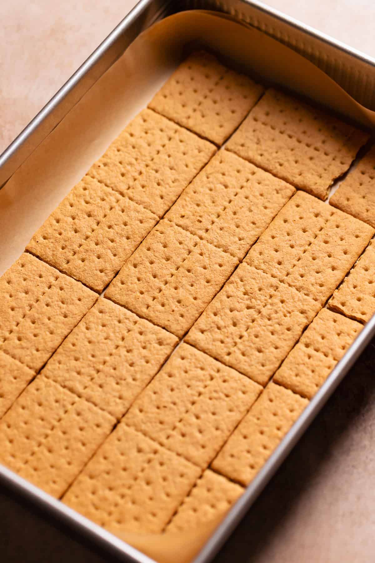 Graham crackers placed on the bottom of a 9x13 baking pan.