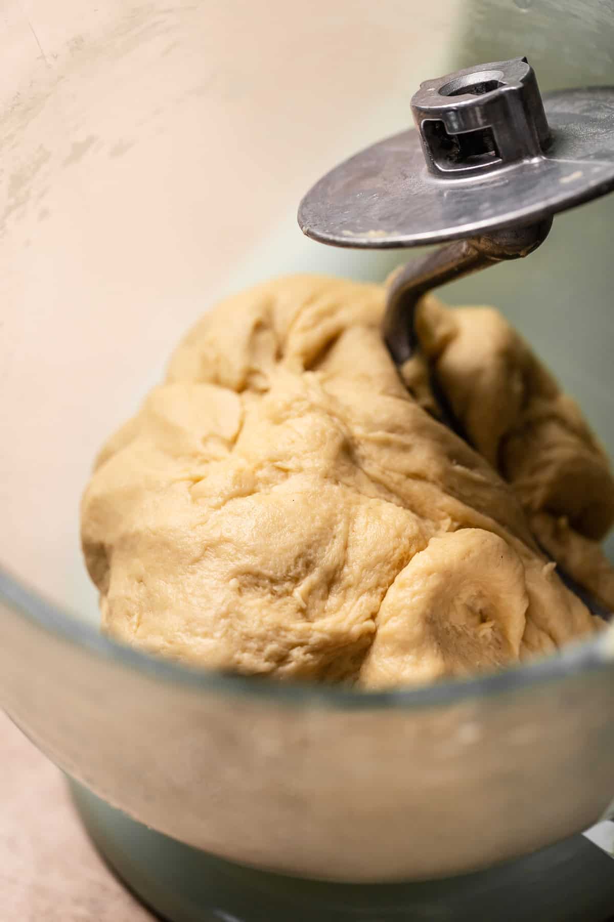 A smooth dough ball in a mixer bowl after kneading.