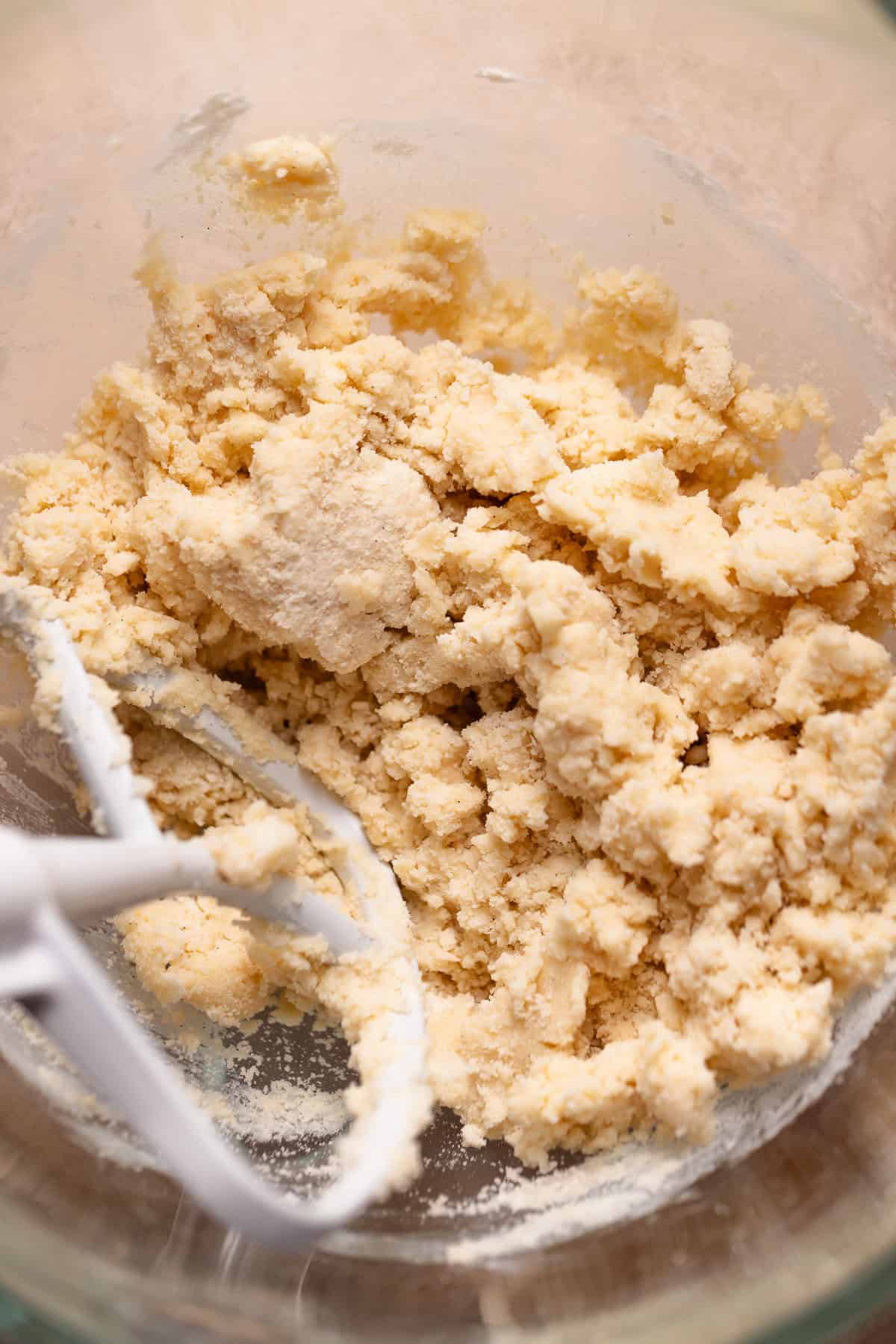Shortbread dough in a glass mixer bowl.