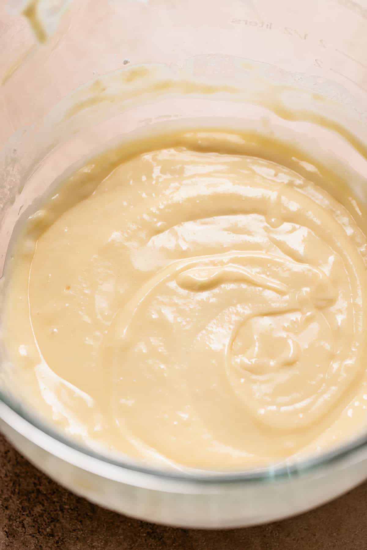 Lemon cupcake batter in a glass mixer bowl.