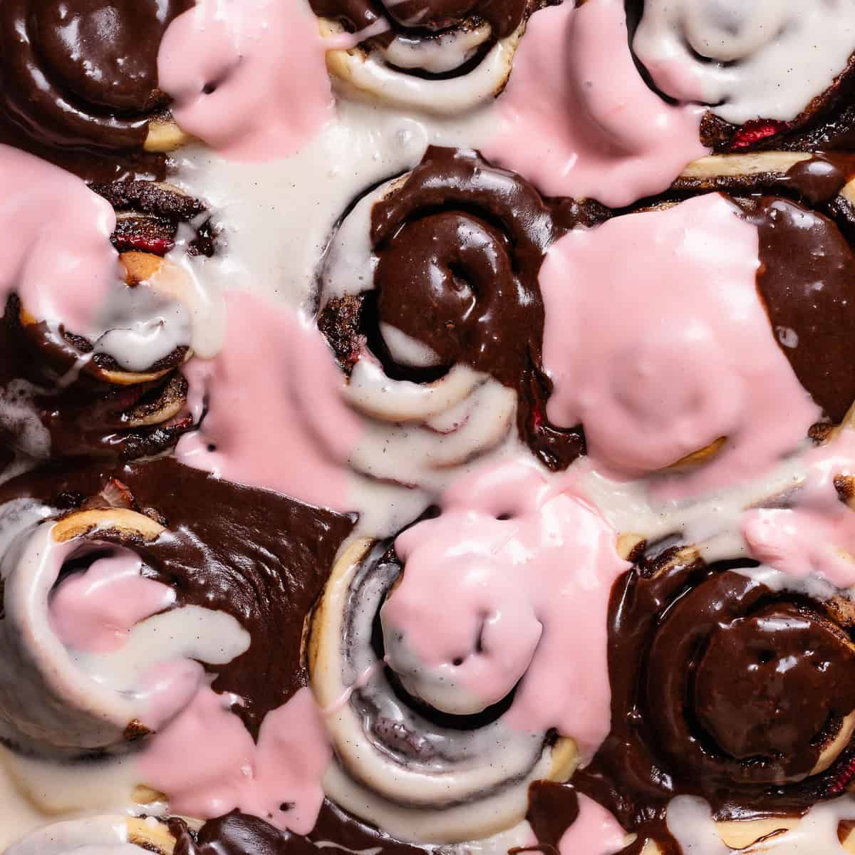 Neapolitan roll in a baking pan with tri-colored icing.