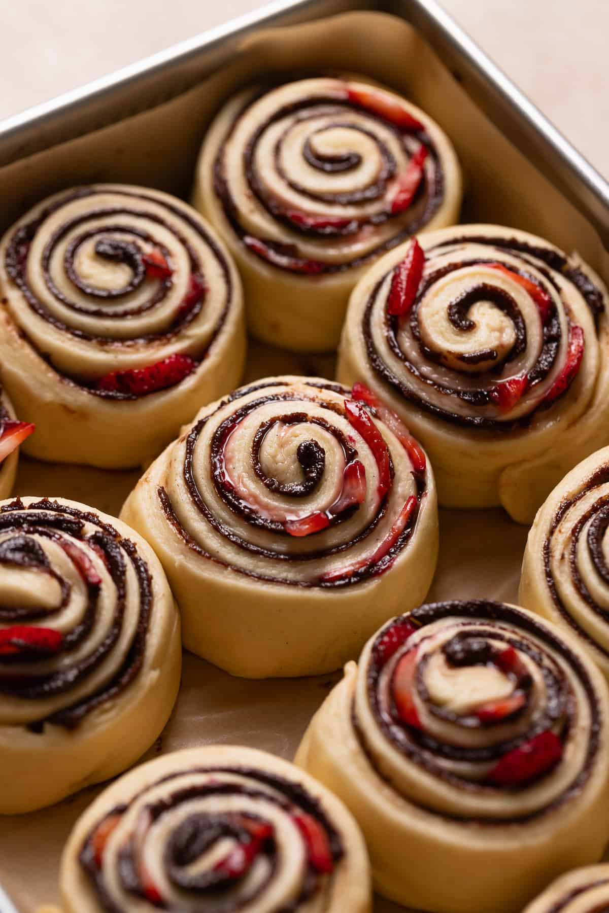 Neapolitan cinnamon rolls in a pan showing that they have doubled in size.