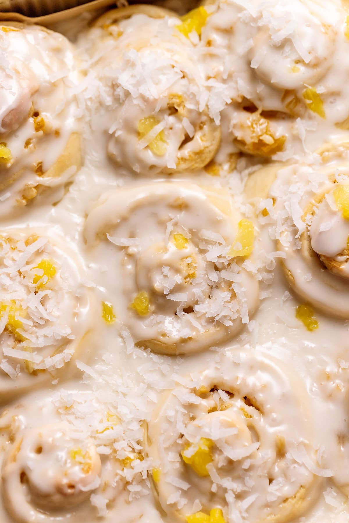 Pina colada cinnamon rolls topped with coconut and pineapple.