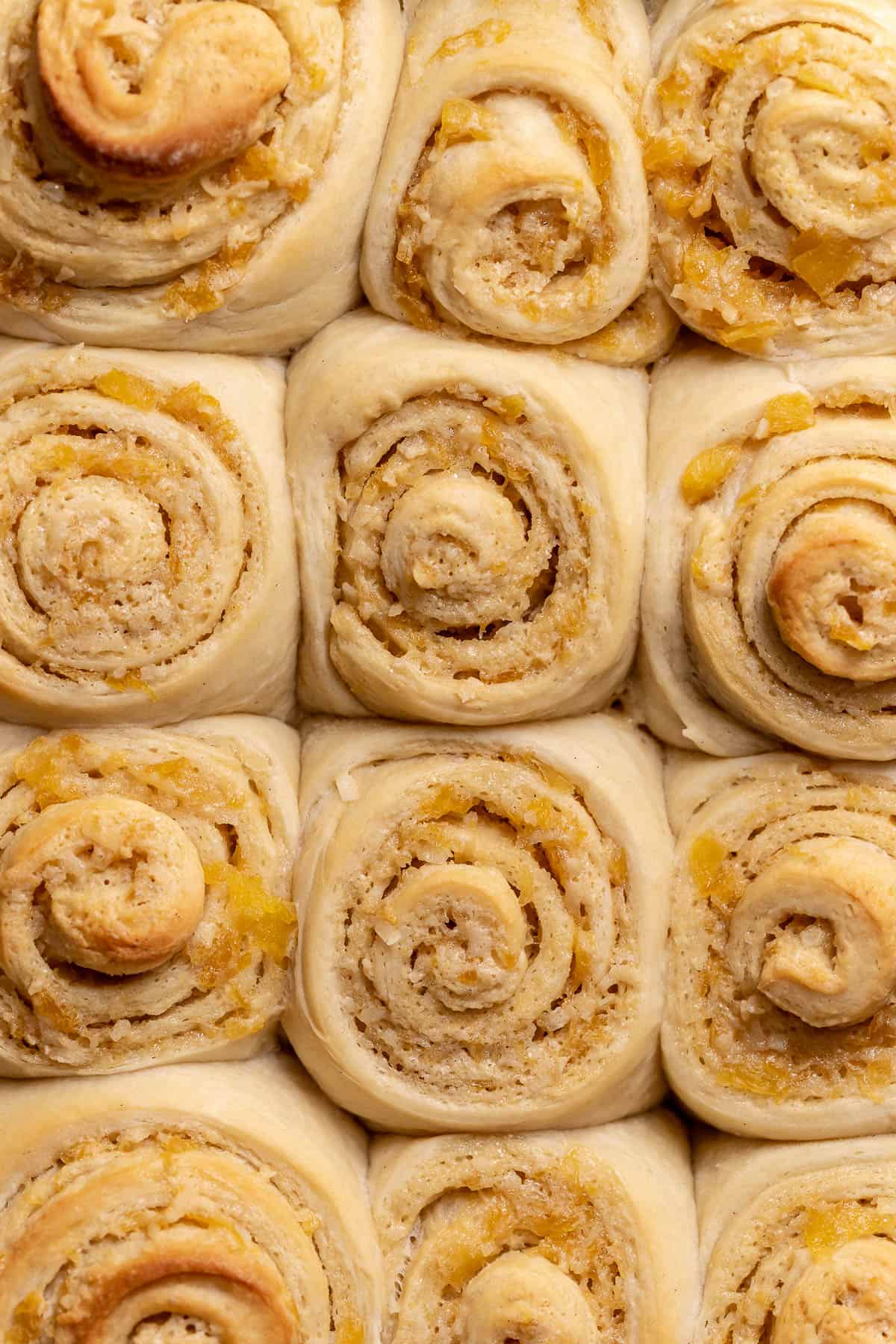 The baked pina colada rolls in a baking pan.
