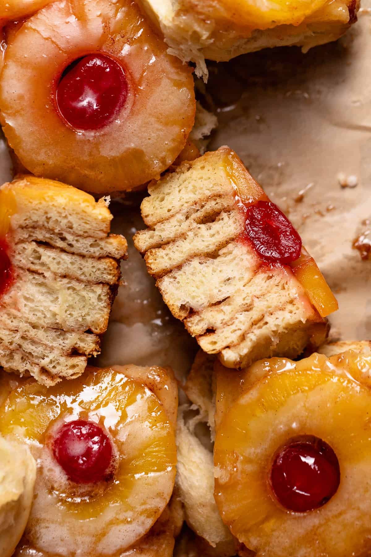 Pineapple upside down roll cut in half on a baking sheets with other rolls.