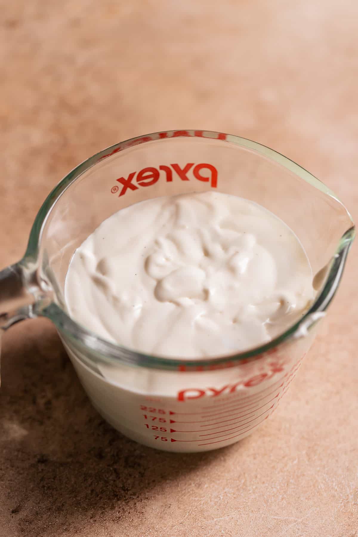 A glass measuring cup full of marshmallow glaze.