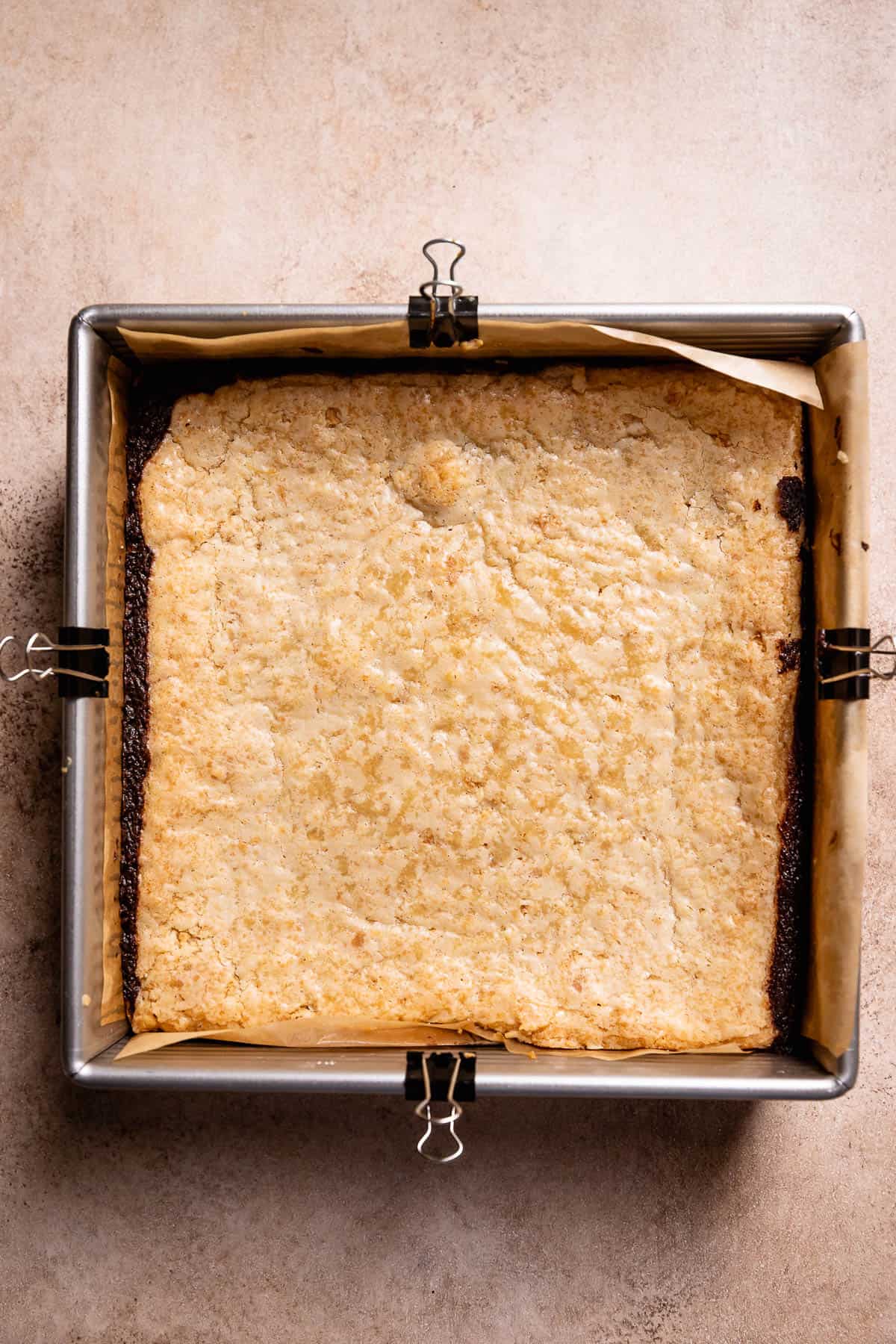 Baked smores bars in a metal baking pan with a lightly golden brown top.