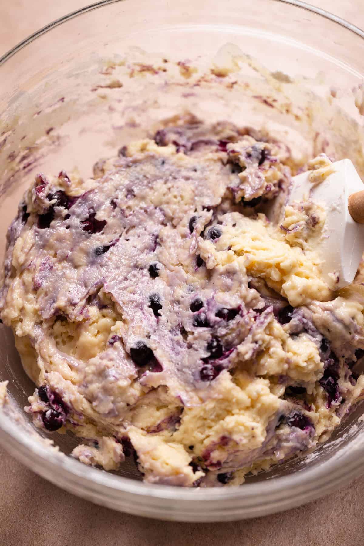 Blueberry cake donut batter in a glass mixing bowl.