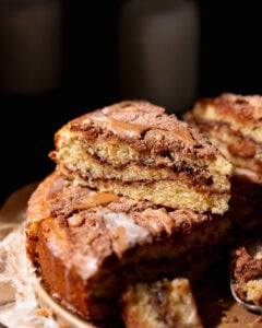 A slice of cinnamon swirl coffee cake stacked on top of other slices of cake.