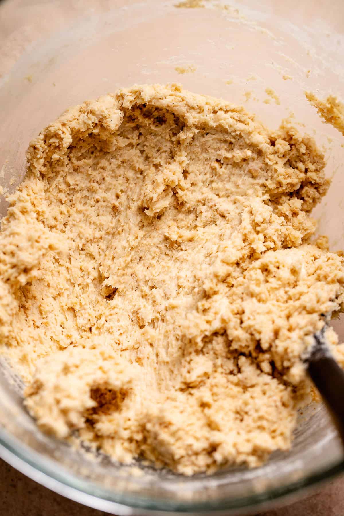 Graham cracker cookie dough in a glass stand mixer bowl.