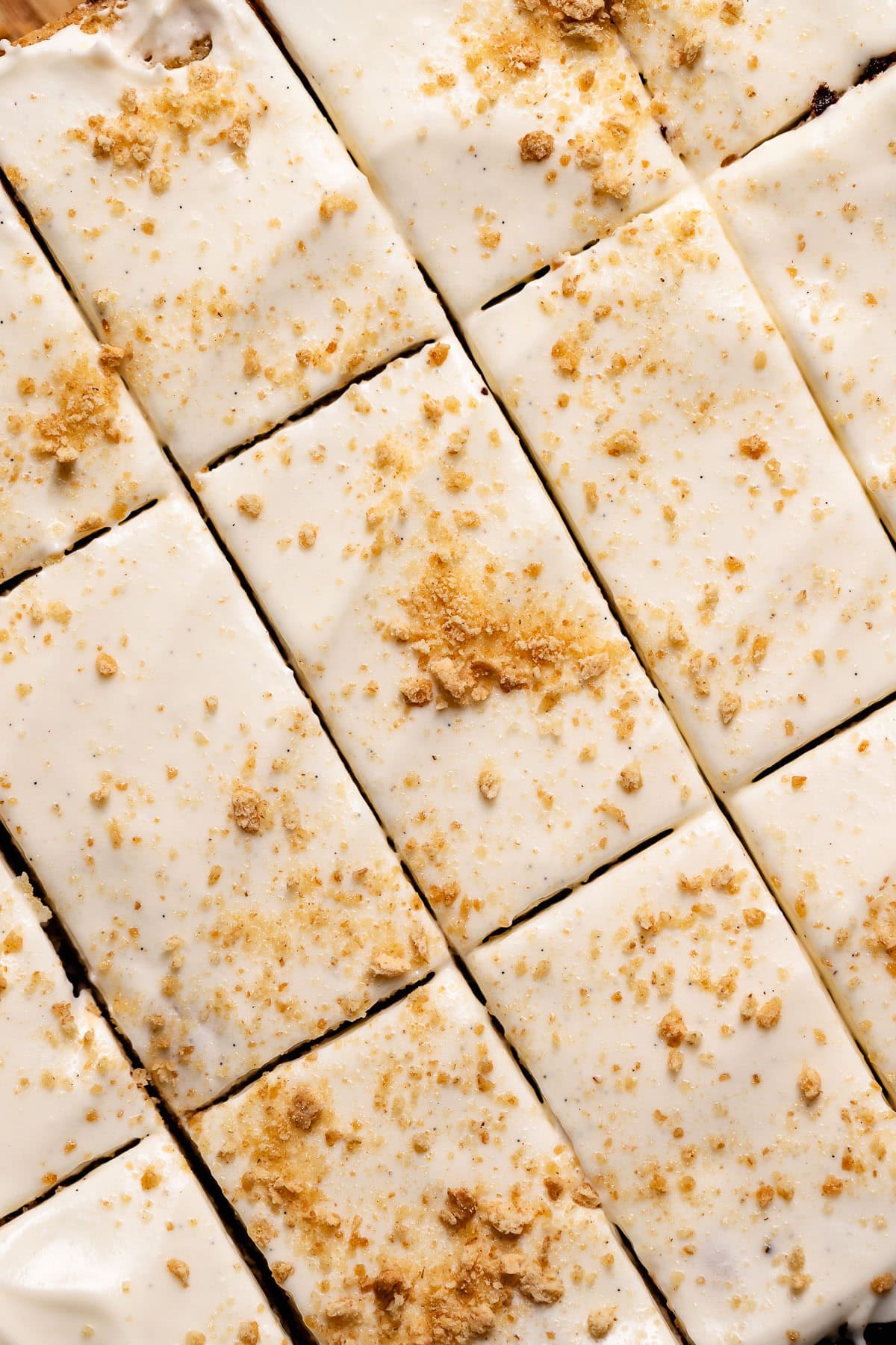 Smores cookie bars with marshmallow frosting cut into squares and sprinkled with graham cracker crumbs.